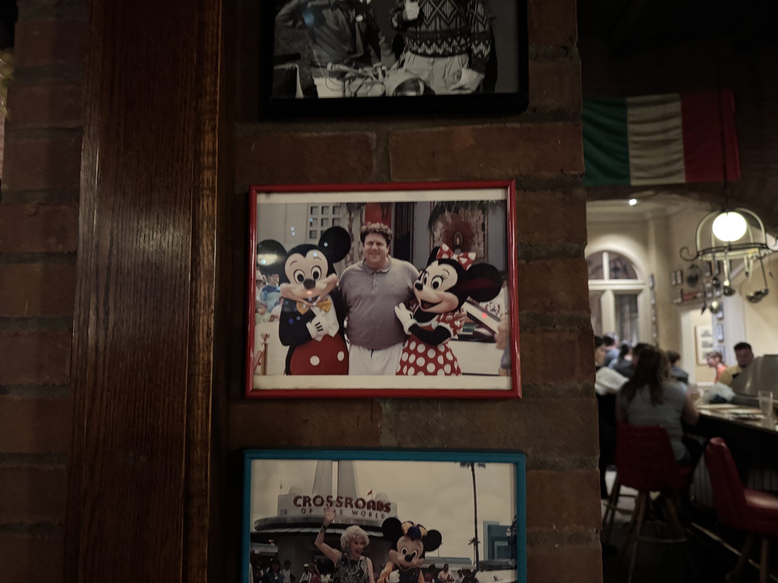 A framed photo at Mama Melrose’s Ristorante Italiano shows a guest with Mickey and Minnie at Disney's Hollywood Studios.