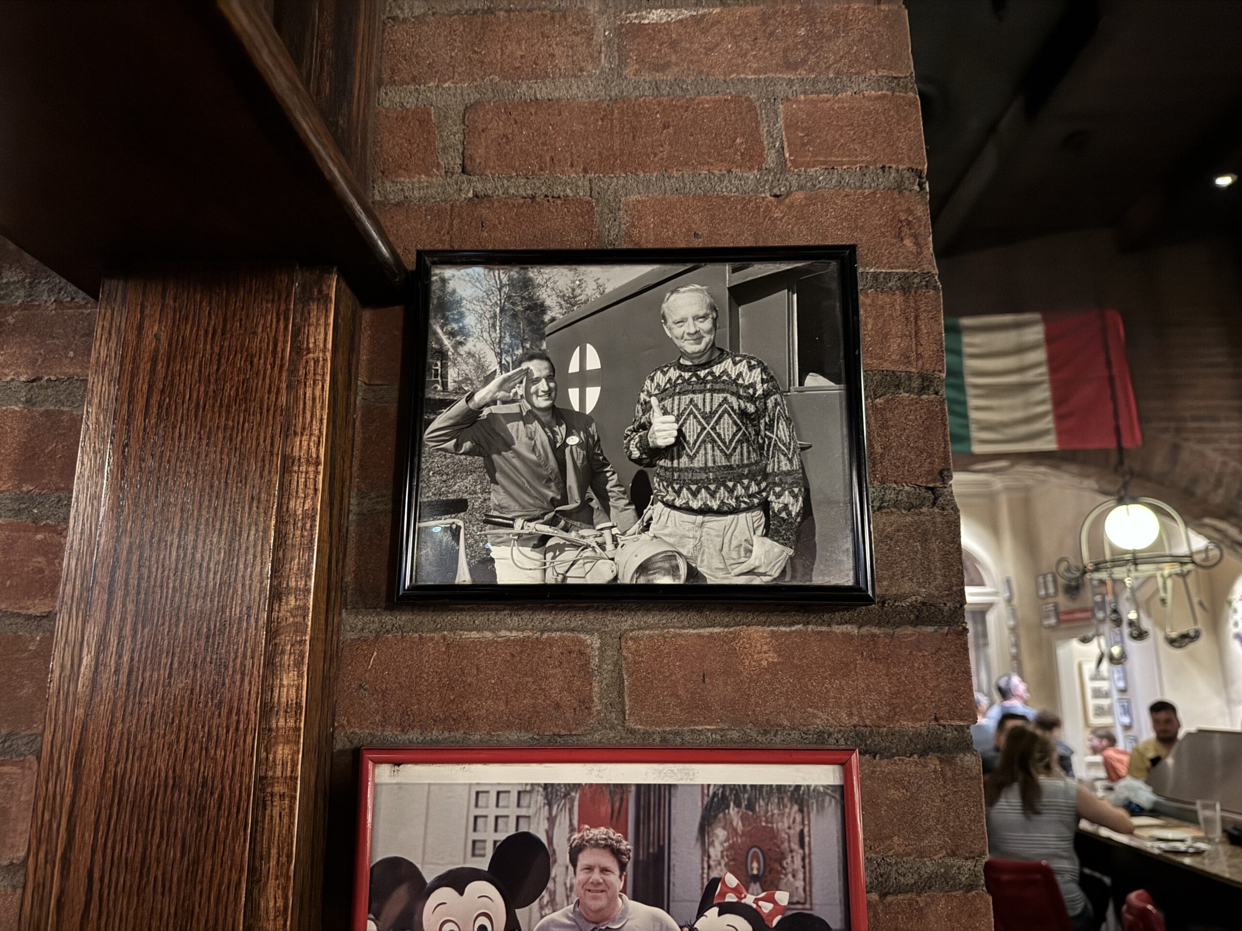 Black-and-white photo of two men smiling at Mama Melrose’s Ristorante Italiano in Disney's Hollywood Studios.