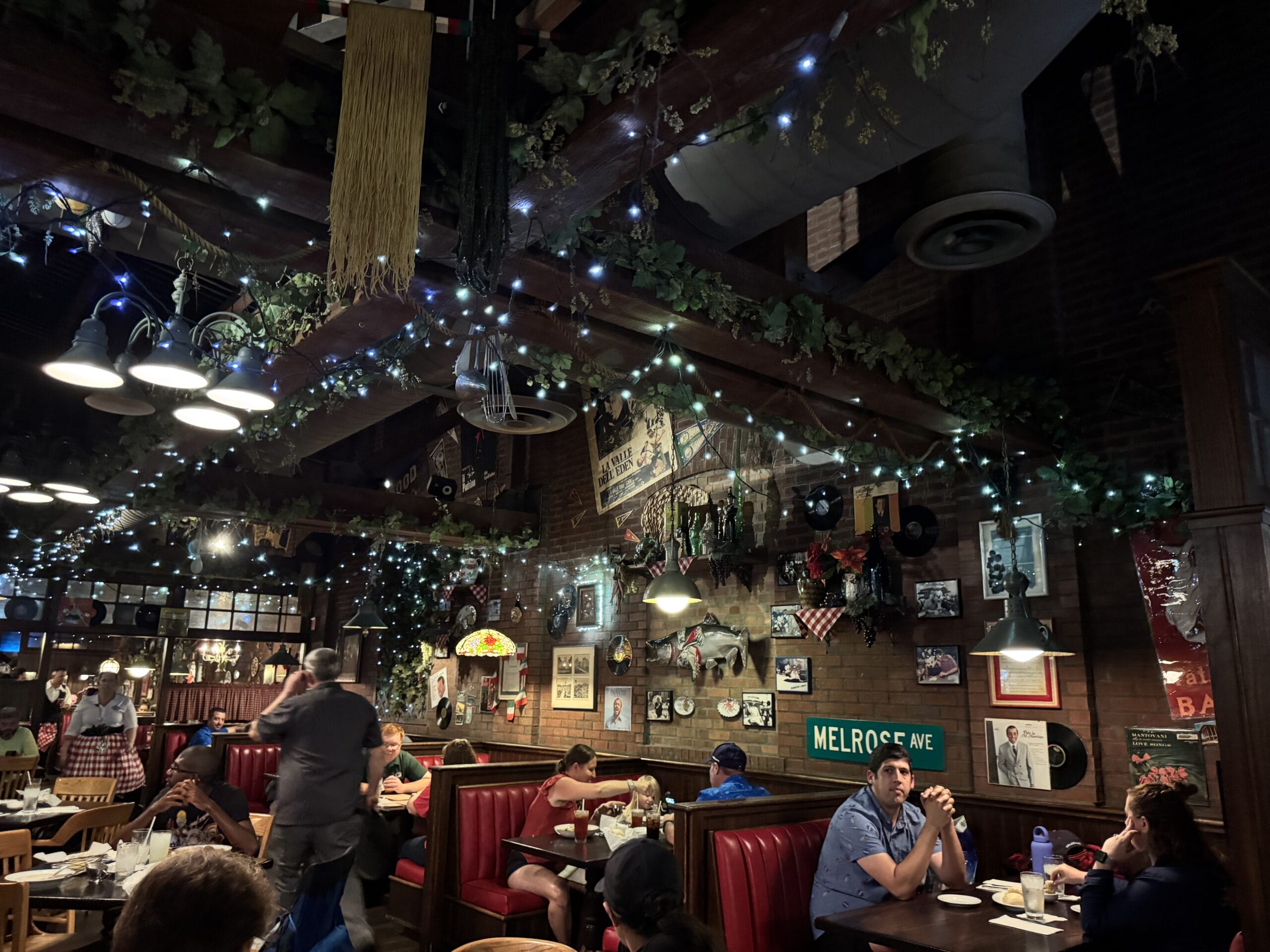 Dimly lit restaurant at Disney's Hollywood Studios with red booths, vintage decor, and cozy vibes—perfect for photos.