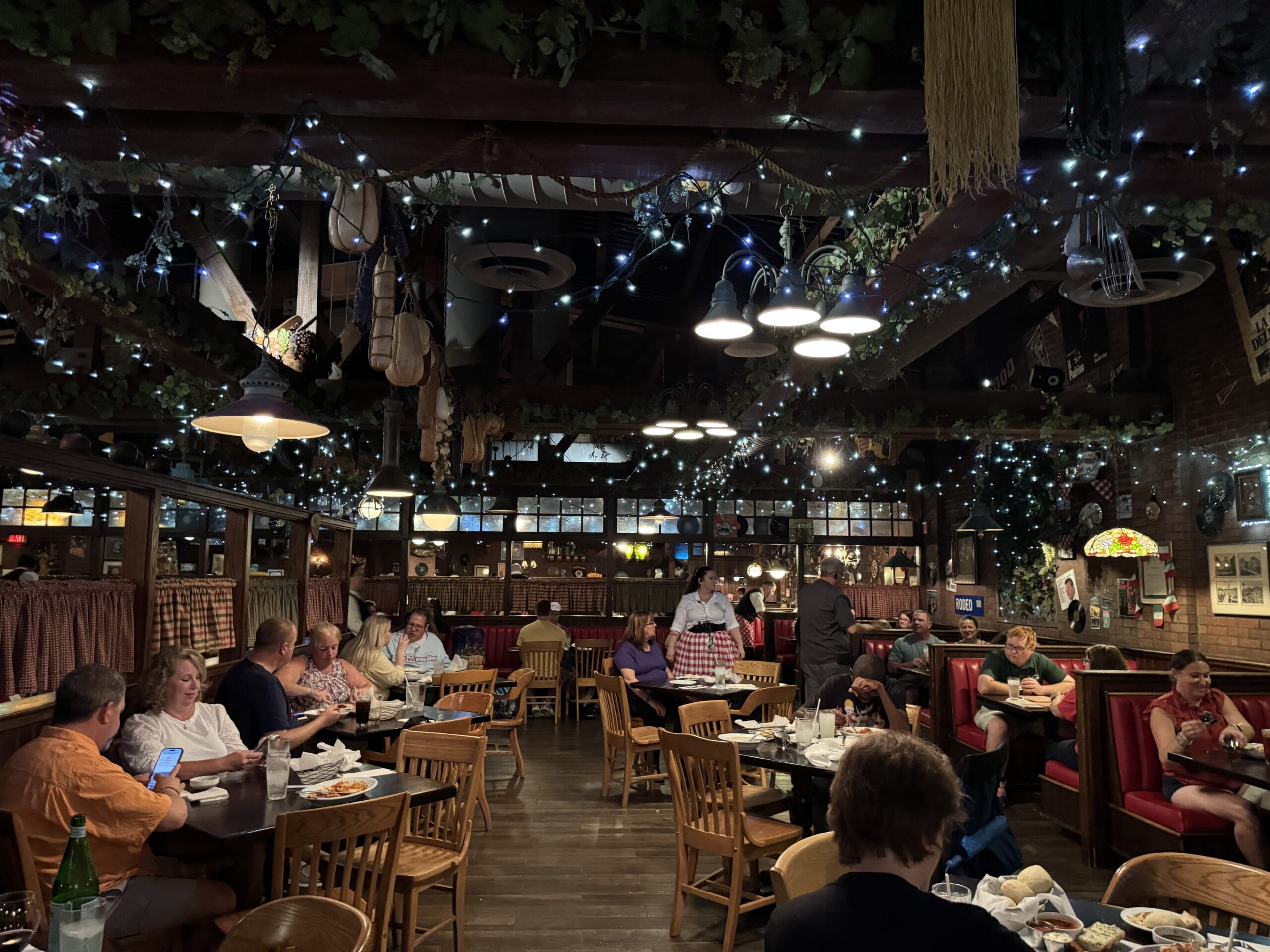 A cozy, dimly lit restaurant at Mama Melrose’s Ristorante Italiano with wooden décor and string lights—perfect for photos.