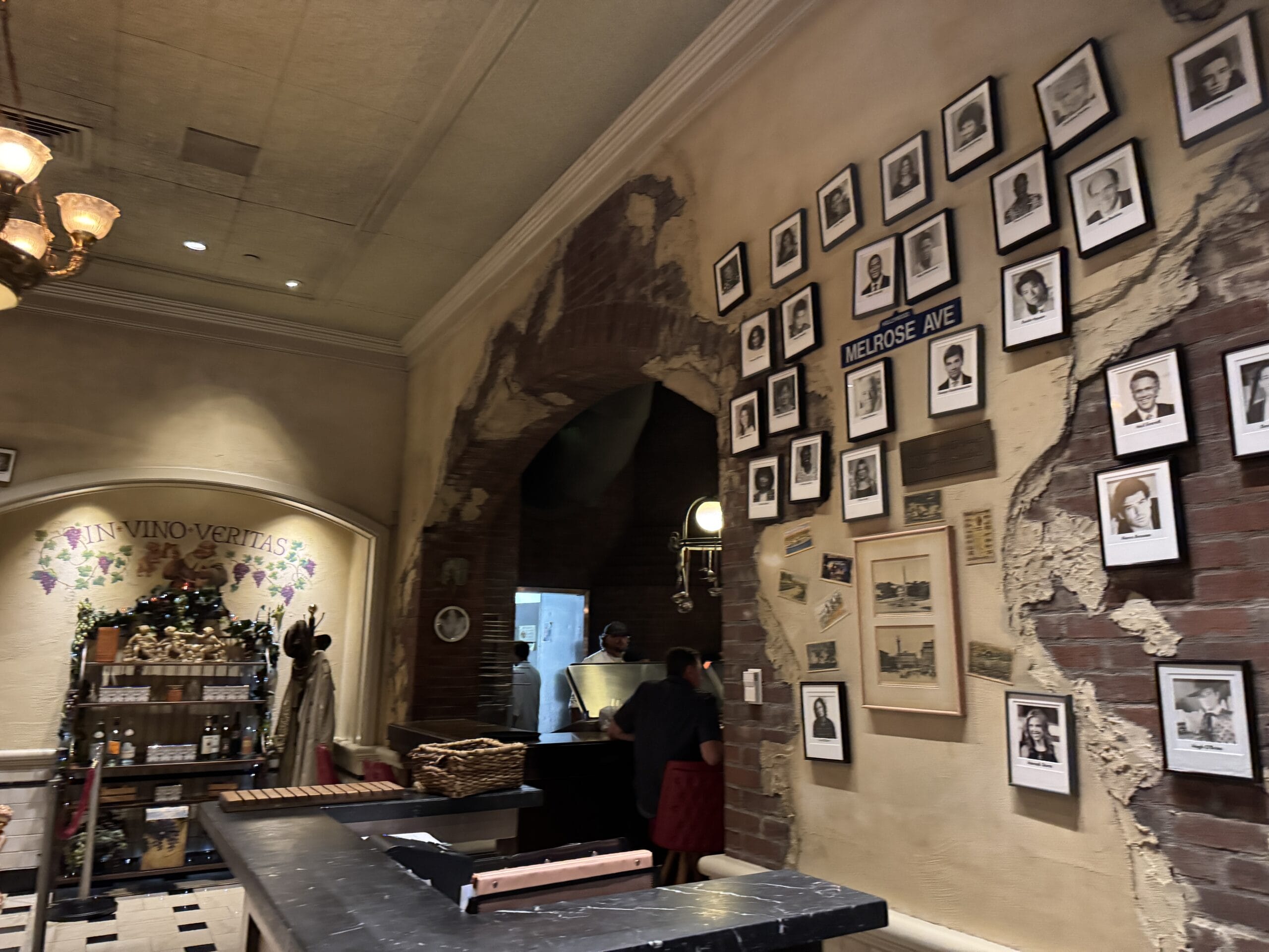 A restaurant at Disney's Hollywood Studios with rustic walls, framed photos, and a staff member near the kitchen entrance.