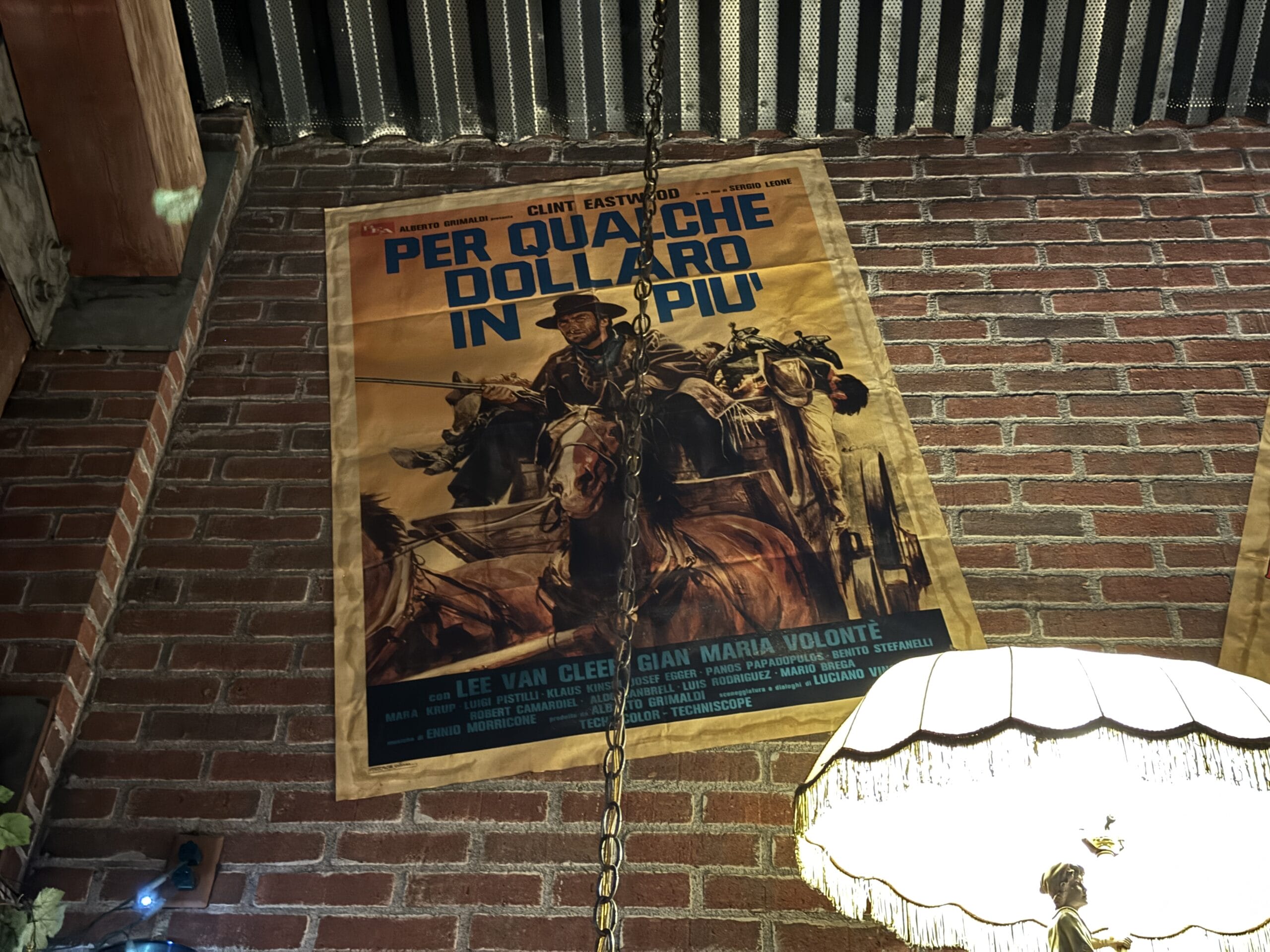 A vintage Italian movie poster hangs above a lamp at Mama Melrose’s Ristorante Italiano in Disney's Hollywood Studios.
