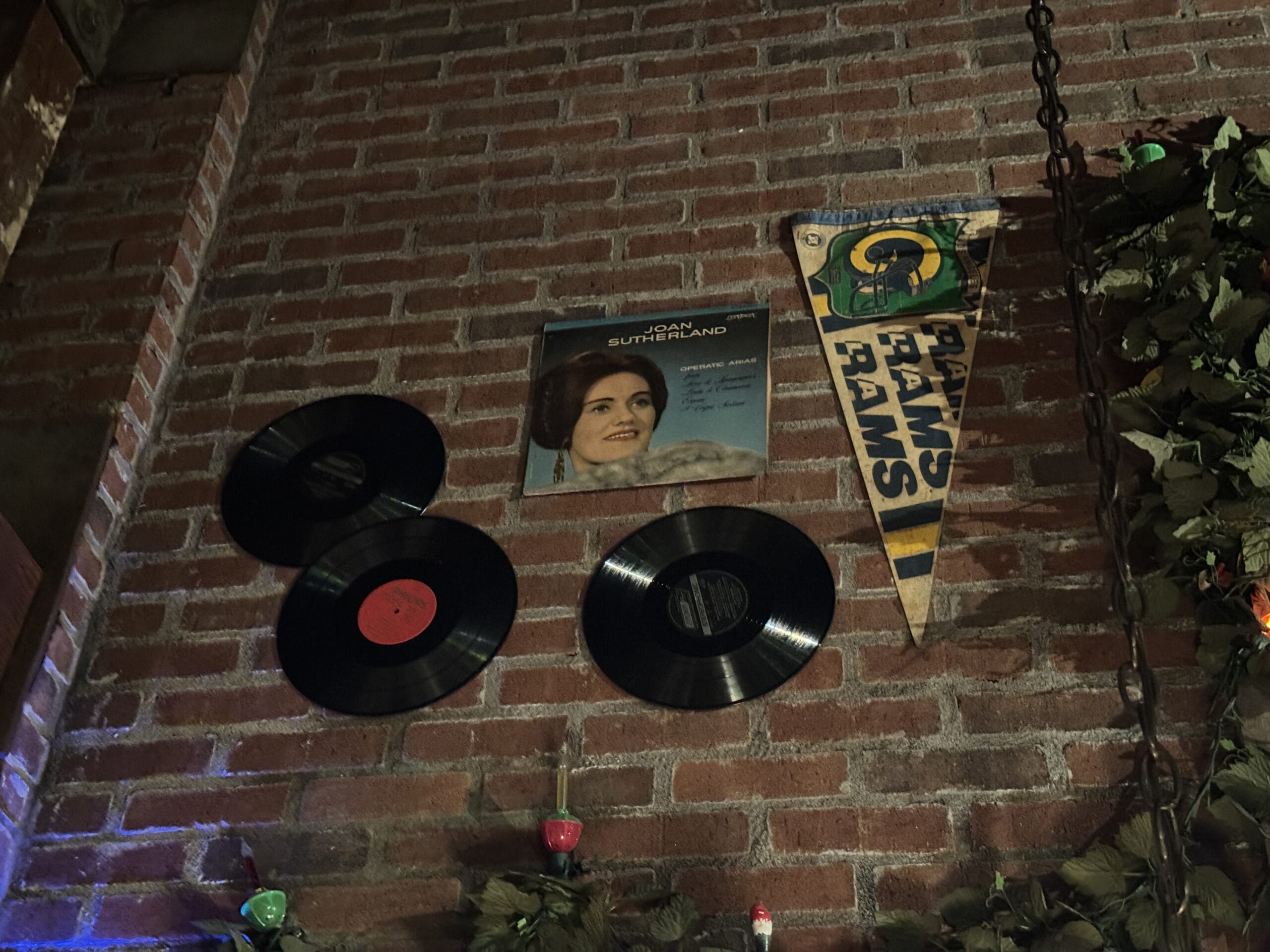 Three vinyl records, a Joan Sutherland album, and a Rams pennant hang at Mama Melrose’s Ristorante Italiano.