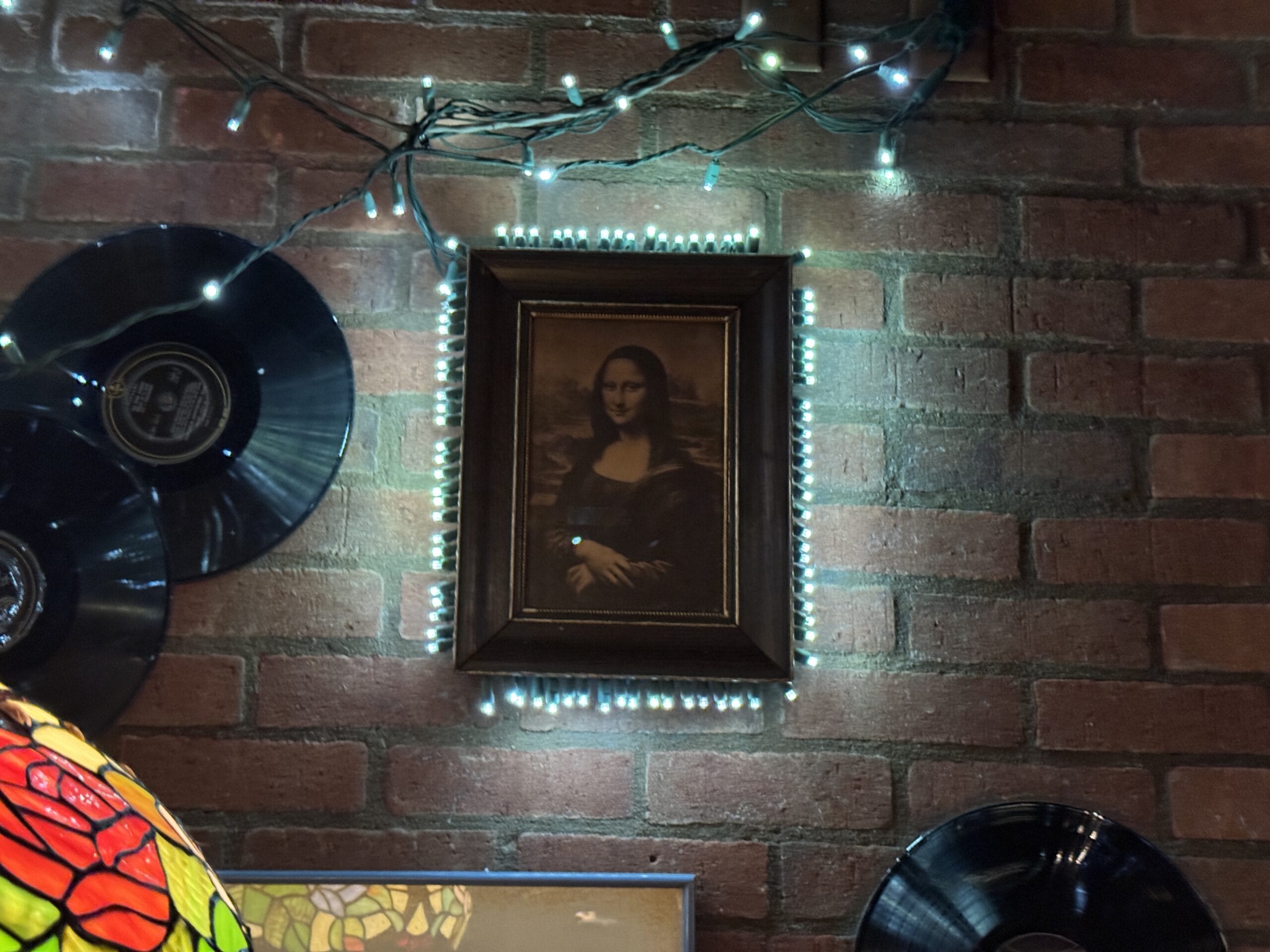 A framed Mona Lisa print brightens the brick wall at Mama Melrose’s Ristorante Italiano in Disney's Hollywood Studios.