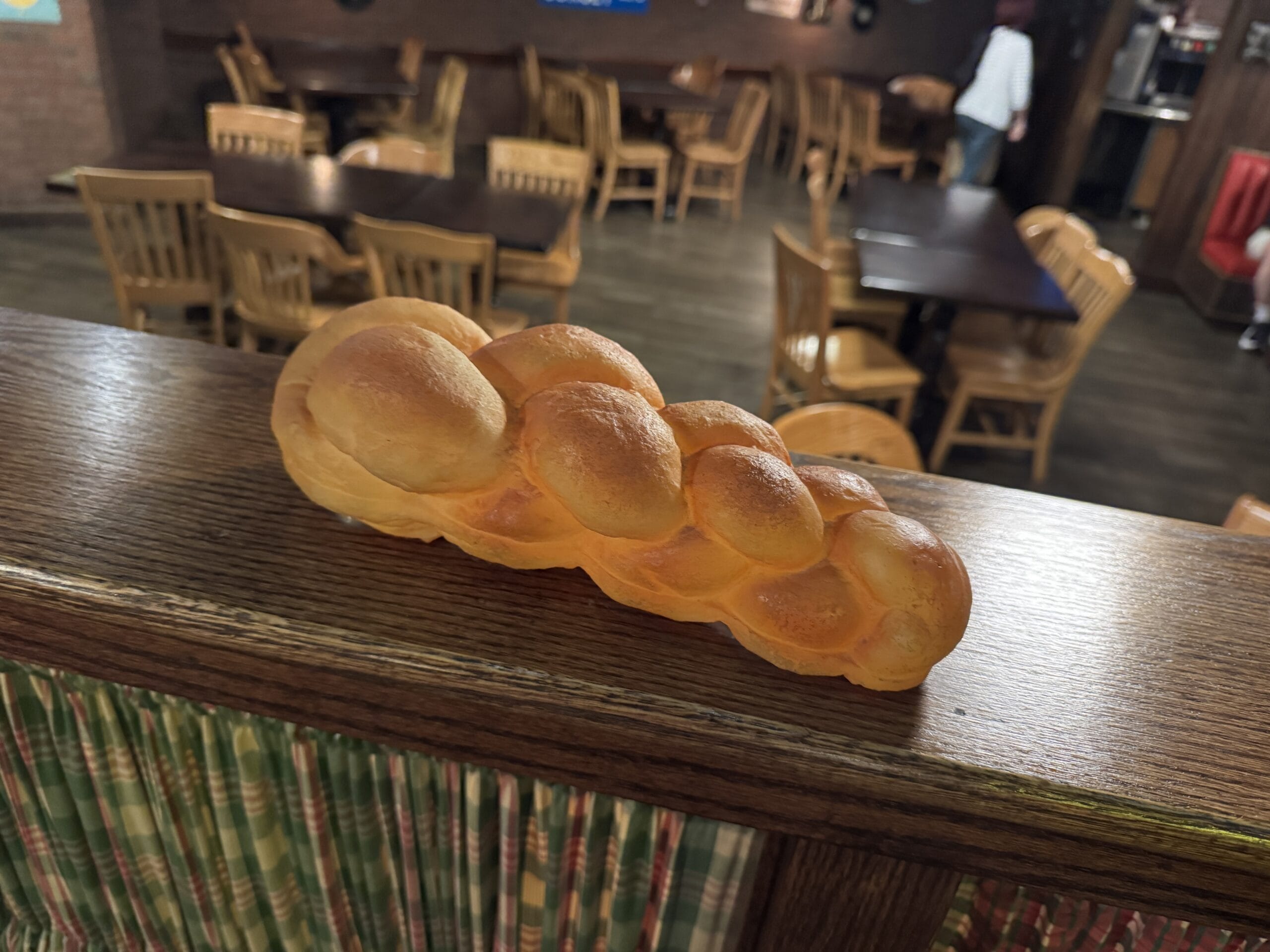 A braided loaf of bread sits on a wooden railing at Mama Melrose’s Ristorante Italiano in Disney's Hollywood Studios.