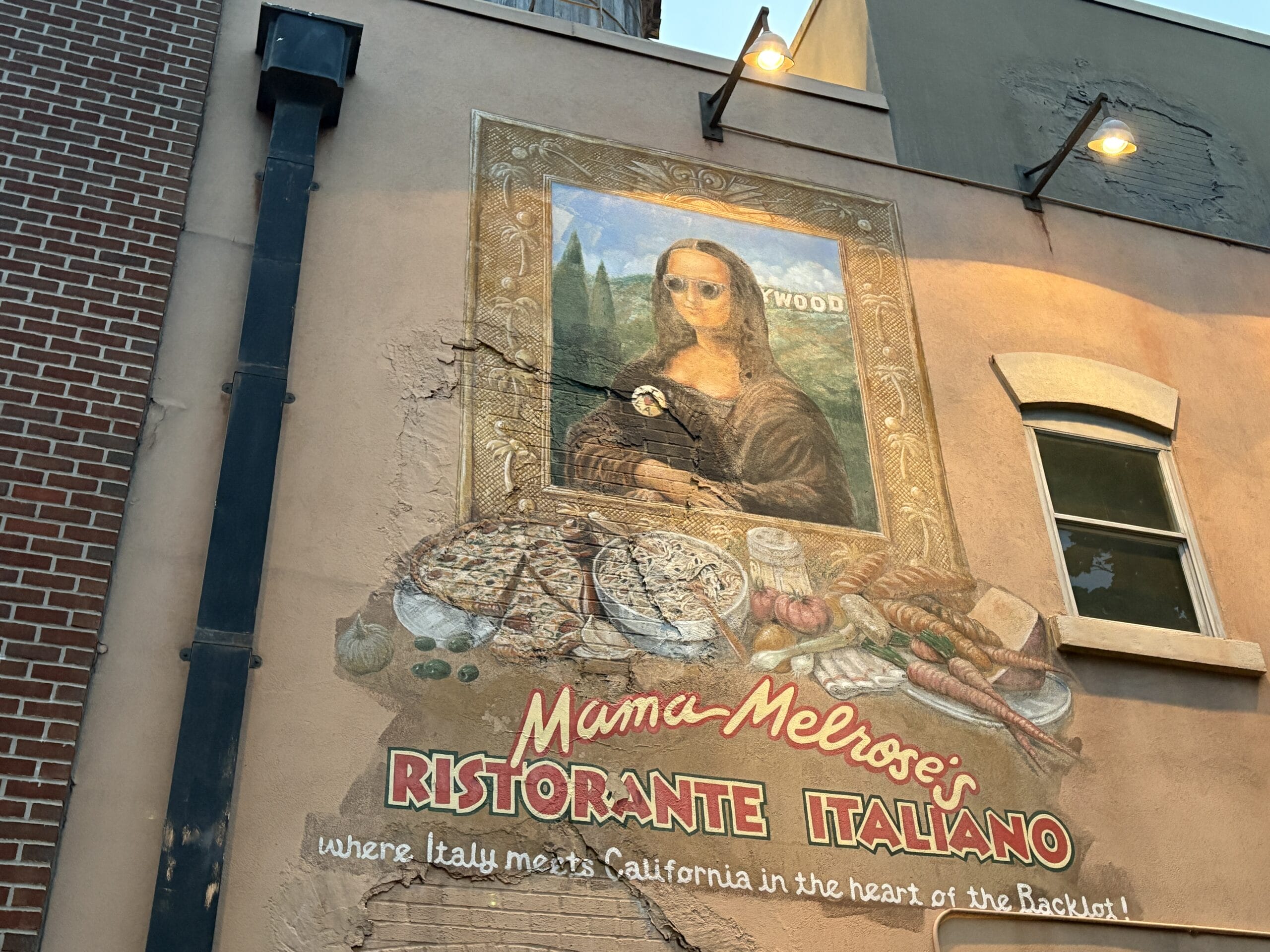 Mural of Mona Lisa with sunglasses above Mama Melrose’s Ristorante Italiano—perfect for fun photos at Disney’s Hollywood Studios.