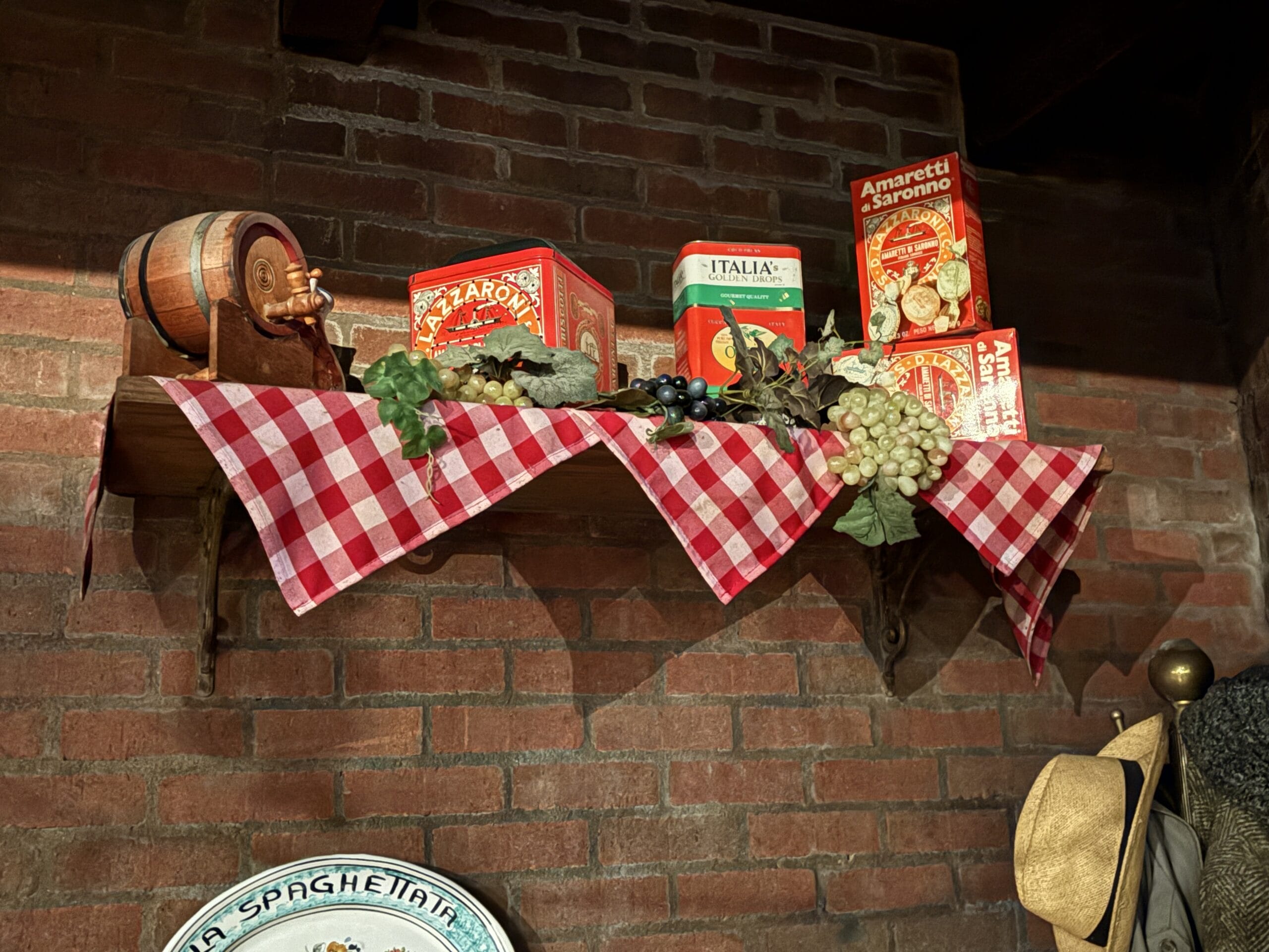 Photos of a shelf at Mama Melrose’s Ristorante Italiano with food tins, grapes, and more in Disney's Hollywood Studios.