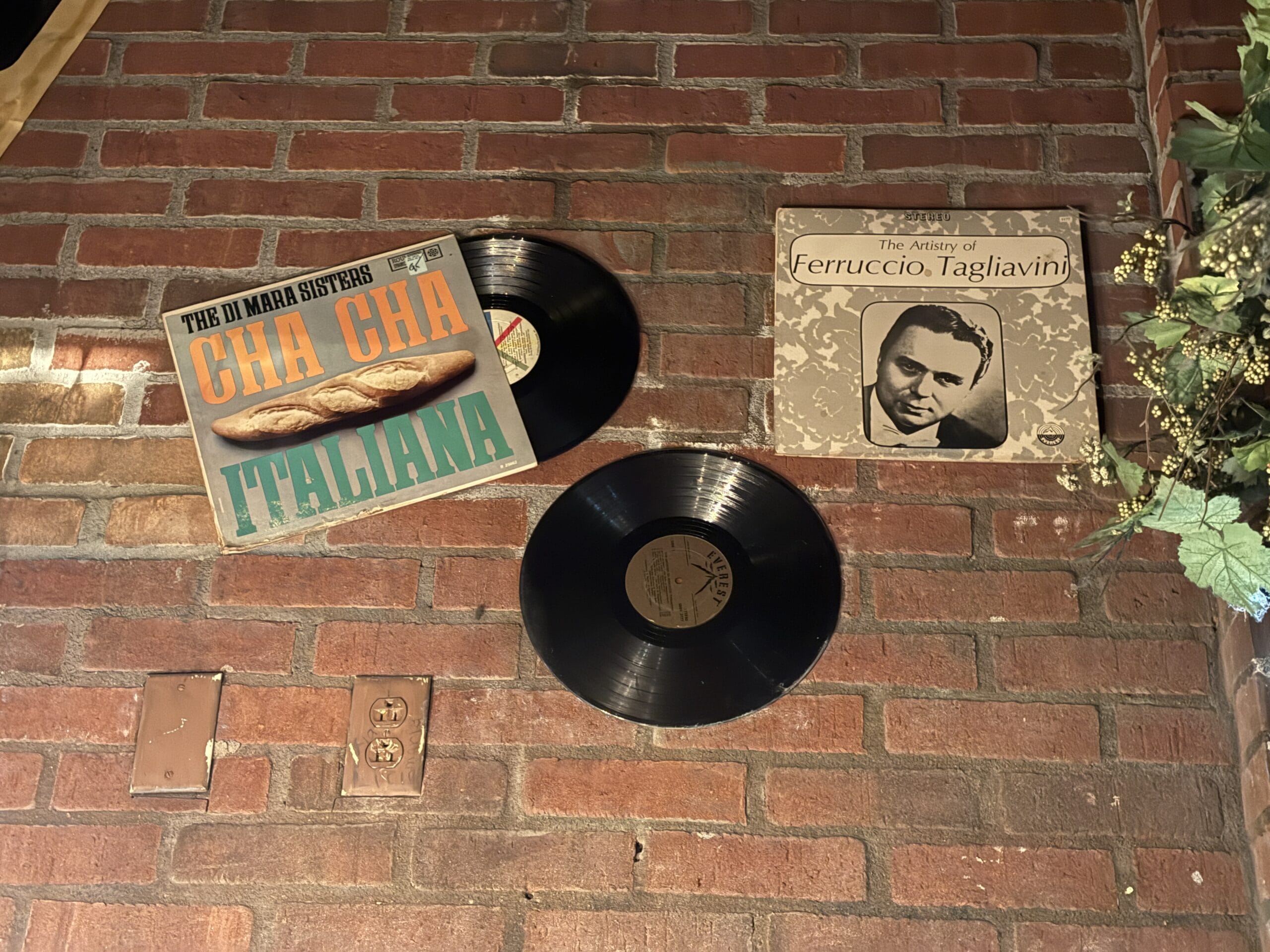Two vinyl records and covers are mounted on a brick wall at Mama Melrose’s Ristorante Italiano in Disney's Hollywood Studios.