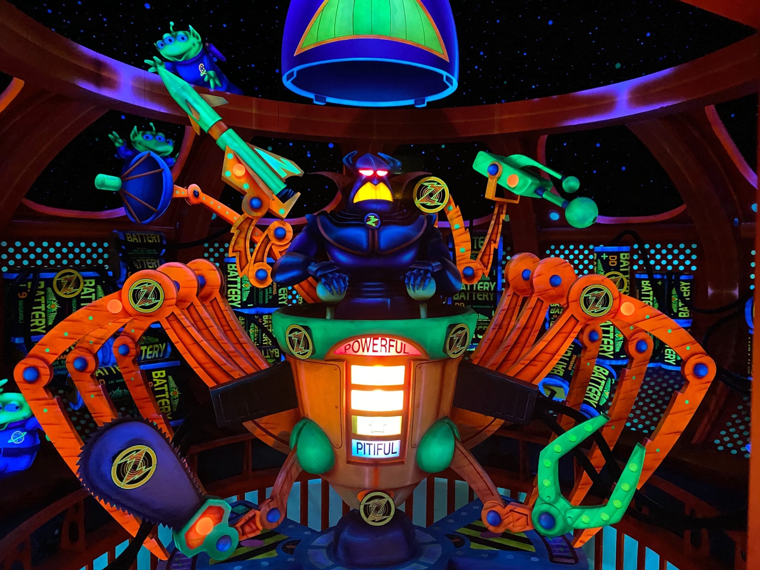 Colorful animatronic of Emperor Zurg with glowing robotic arms in a Tomorrowland-inspired, space-themed blacklight setting. Colorful animatronic of Emperor Zurg with glowing robotic arms in Tomorrowland