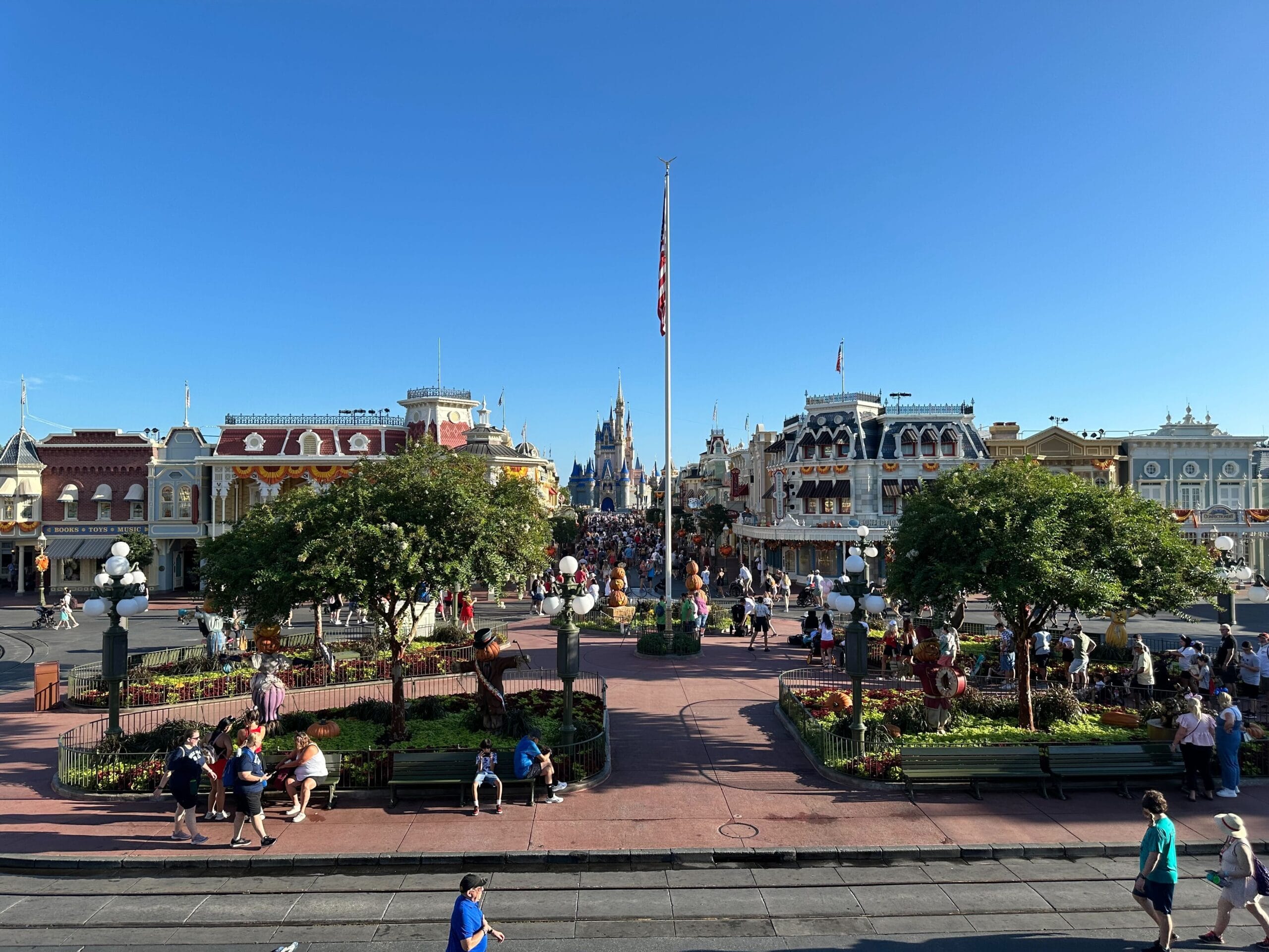 View of Main Street, U.S.A. at Disney World in Orlando, with Cinderella Castle and a clear blue sky.