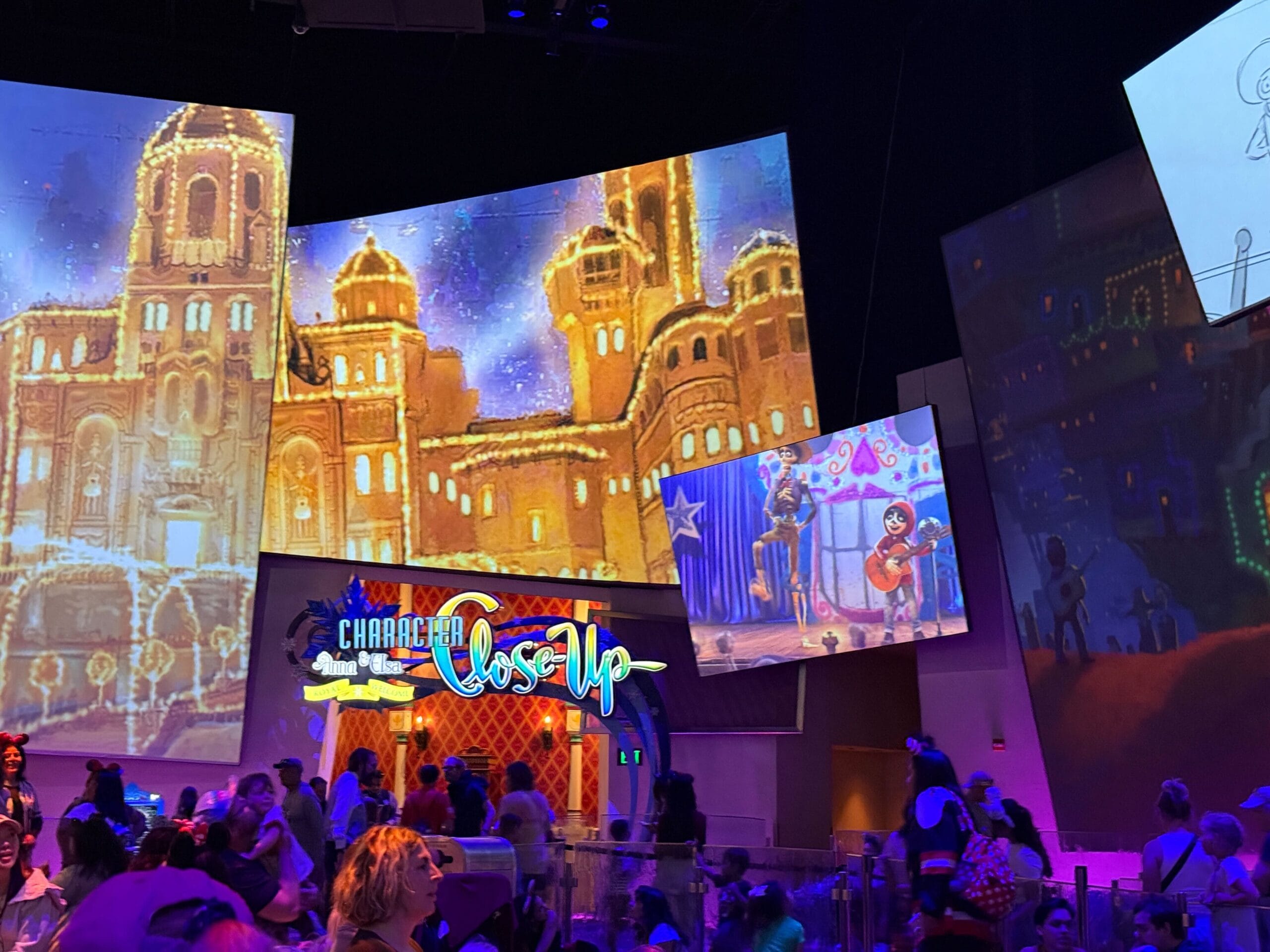 Colorful indoor exhibit with animated scenes from "Coco," crowds, and a sign reading "Character Close-Up.