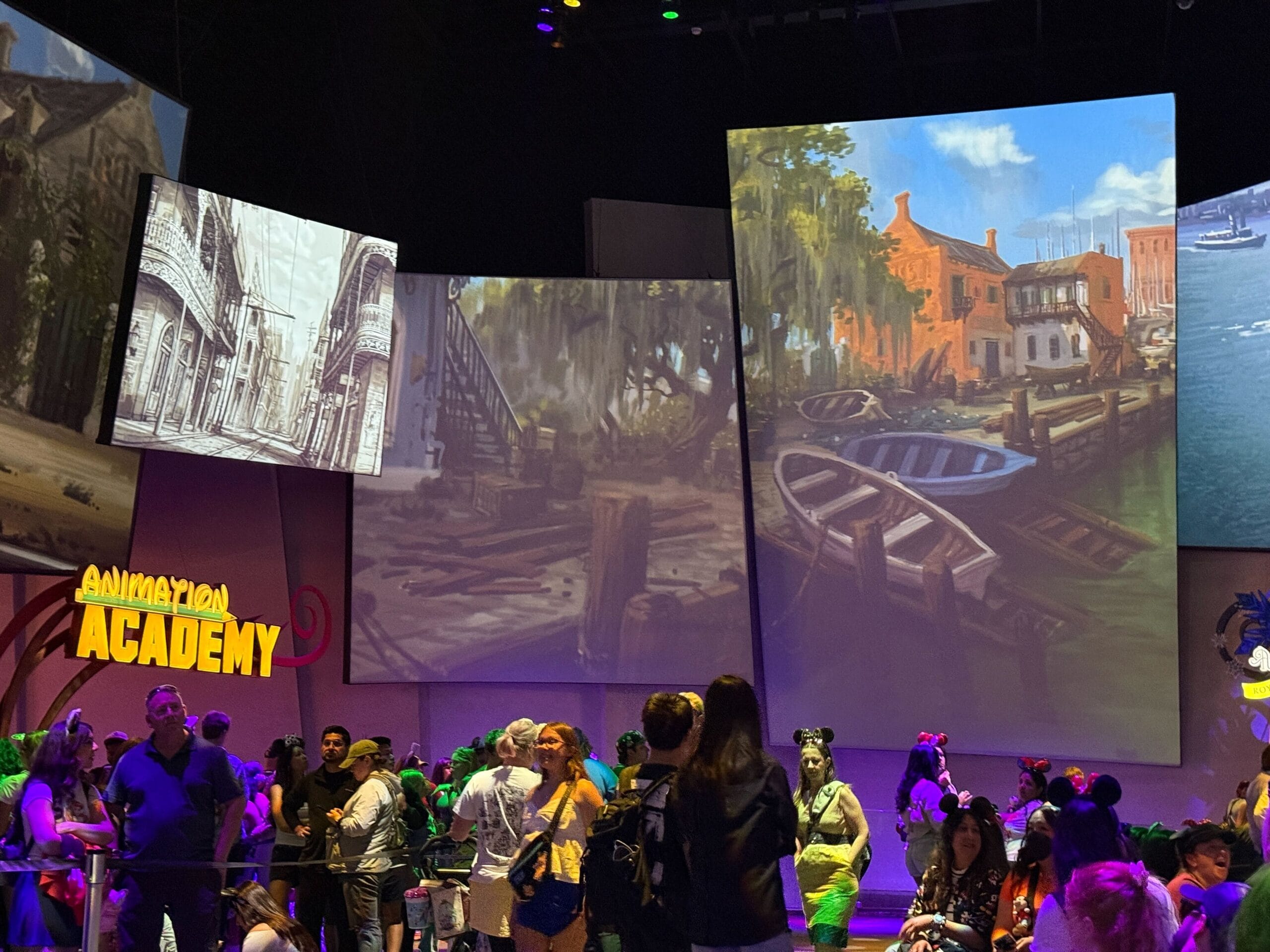 Crowd gathers at Animation Academy, with large painted scenes of boats and buildings displayed on screens above.
