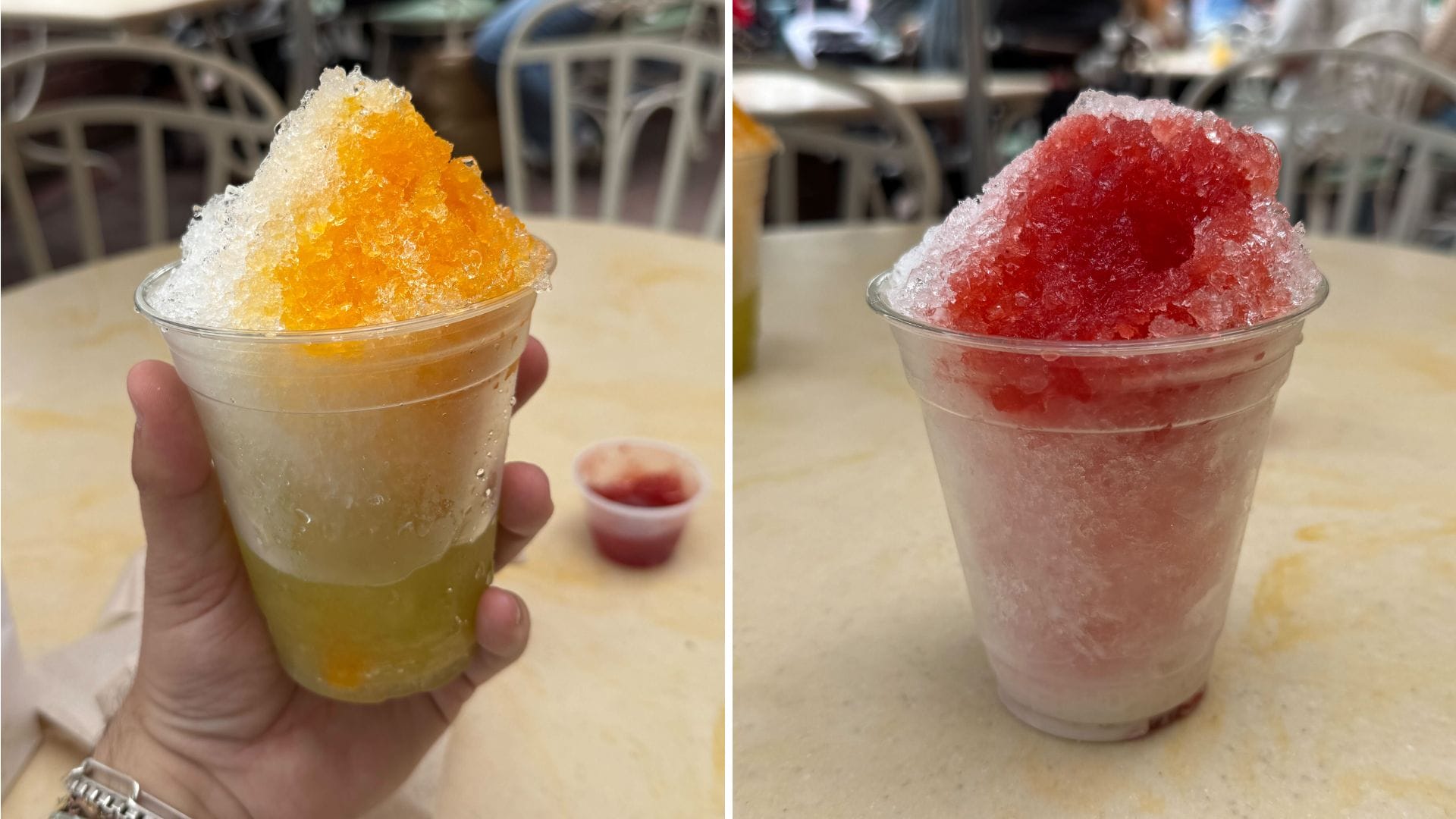 Two cups of shaved ice: one with orange syrup, the other with red syrup, on an outdoor table.