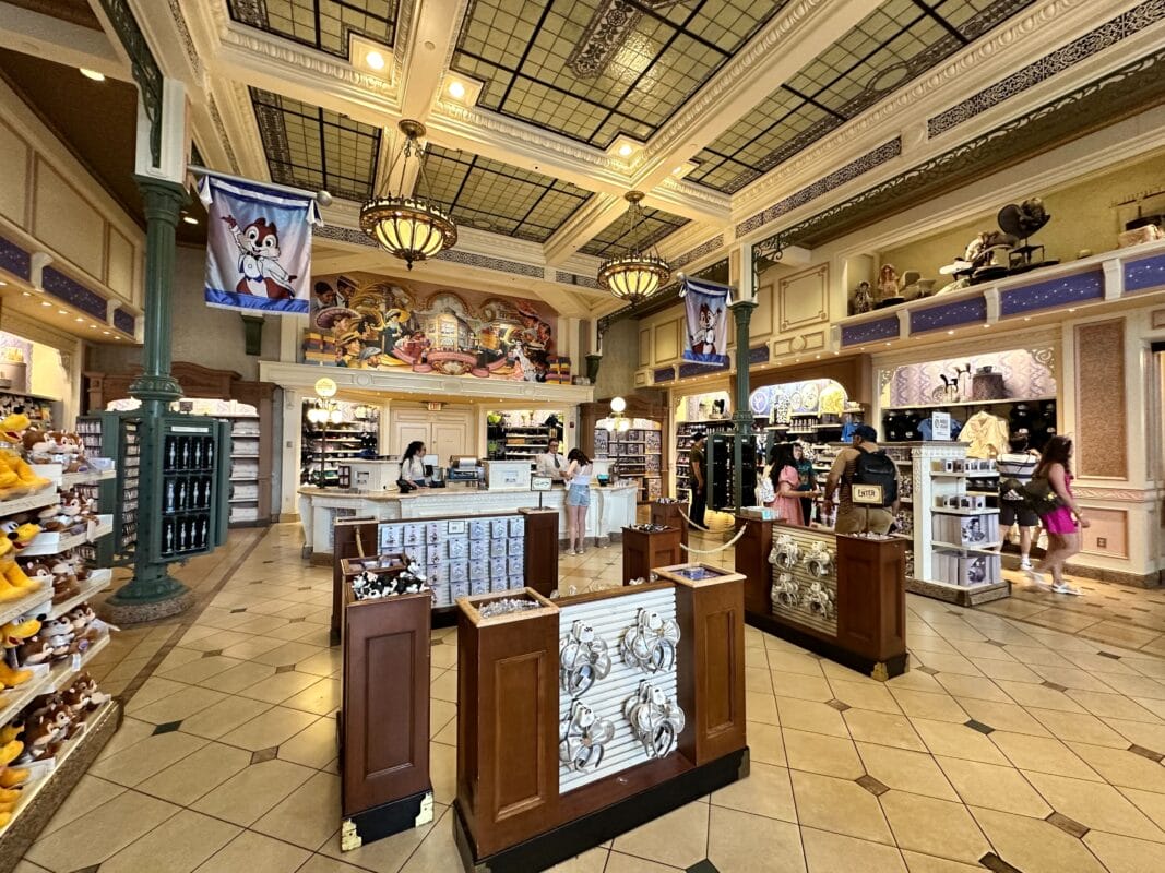 Main Street USA Emporium with plush toys, souvenirs, and shoppers in a brightly lit, ornate store interior.
