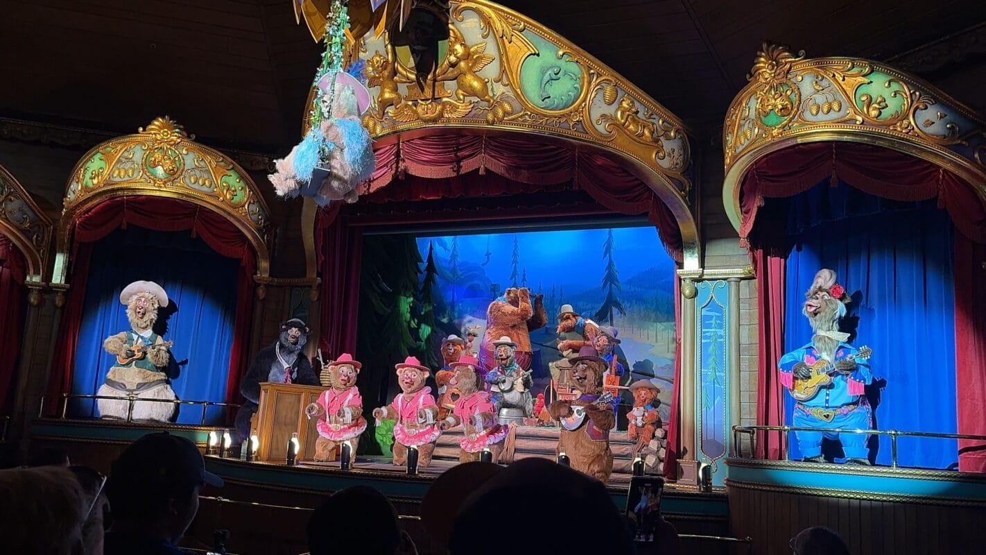 Animatronic bears in costumes perform on a decorated stage in Frontierland
