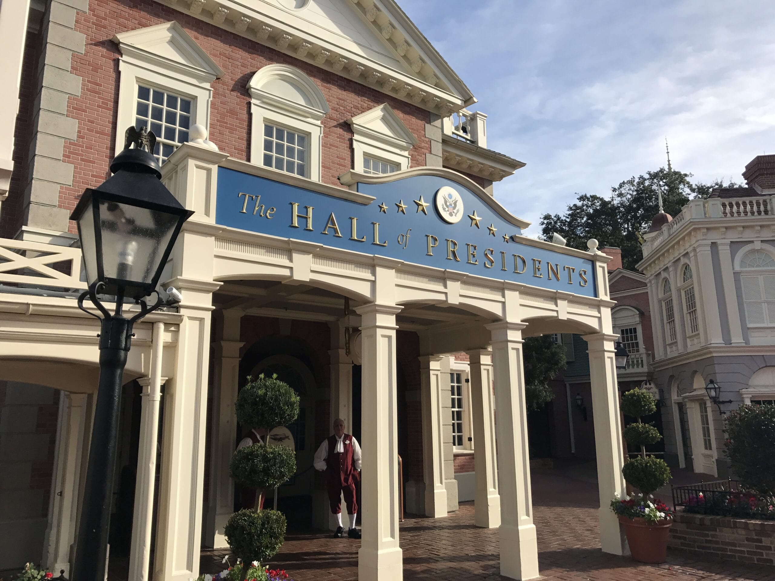 Entrance to The Hall of Presidents in Liberty Square with a costumed greeter beneath the sign at Disney World.