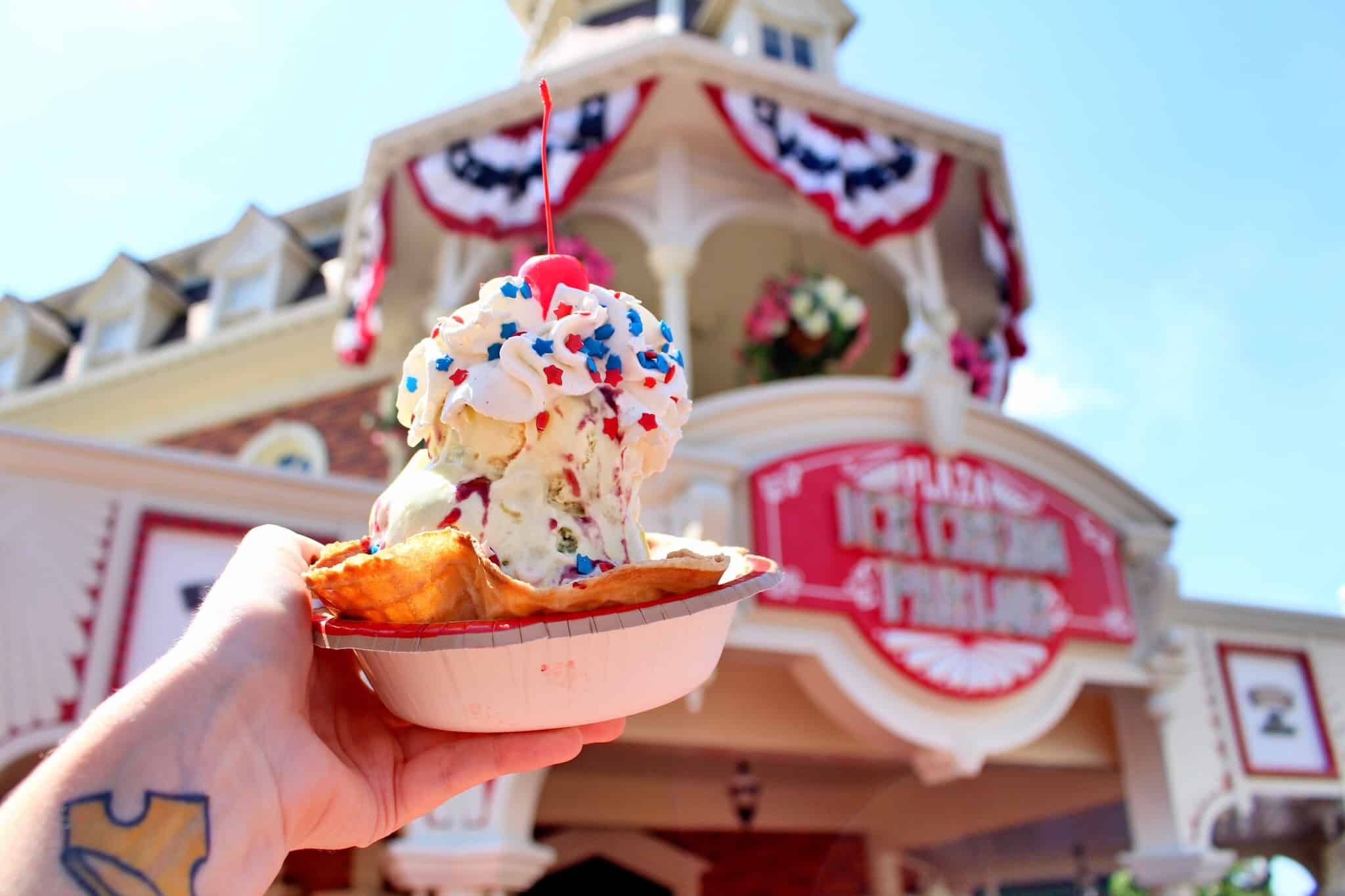 An ice cream sundae with sprinkles on Main Street USA, in front of the Plaza Ice Cream Parlor