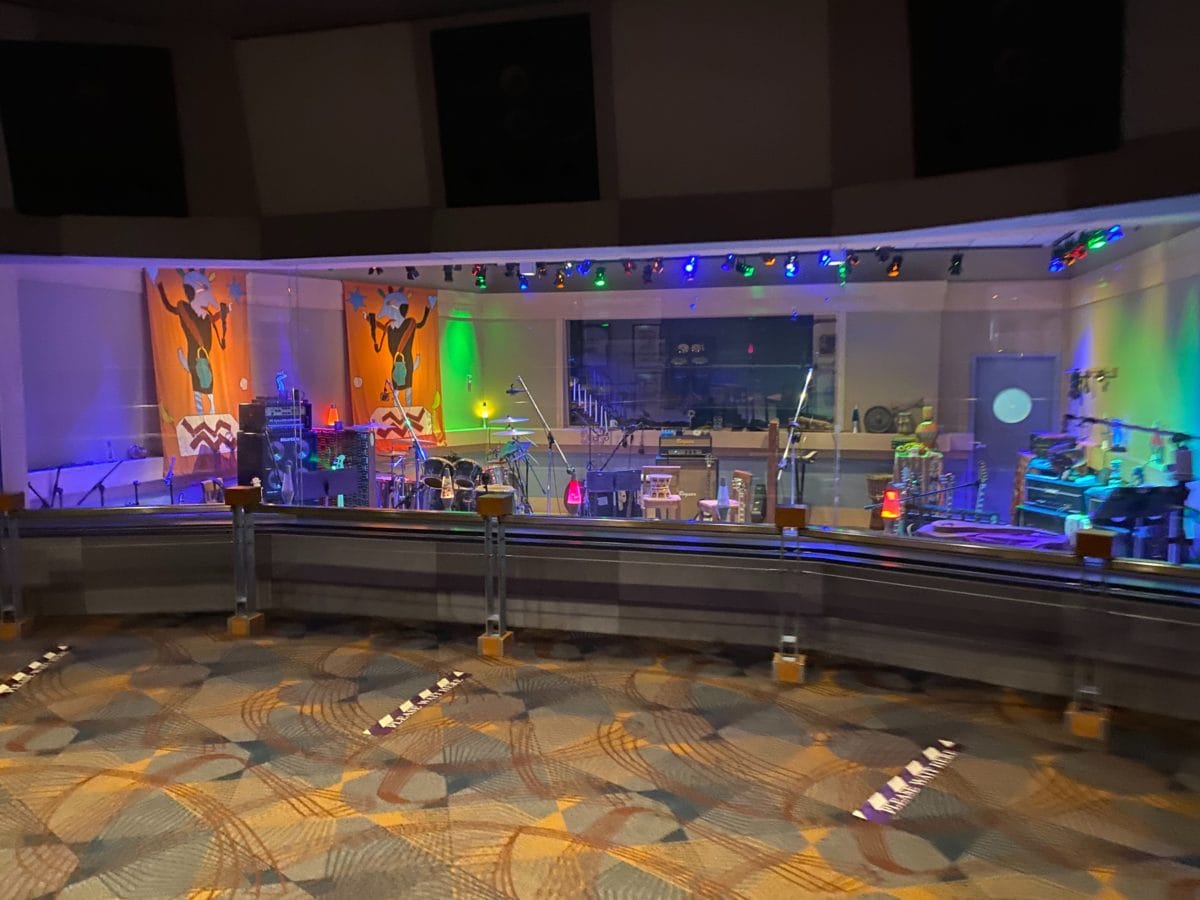 A colorful music studio with instruments and vibrant wall art, of Disney's Rock n Roller Coaster queue