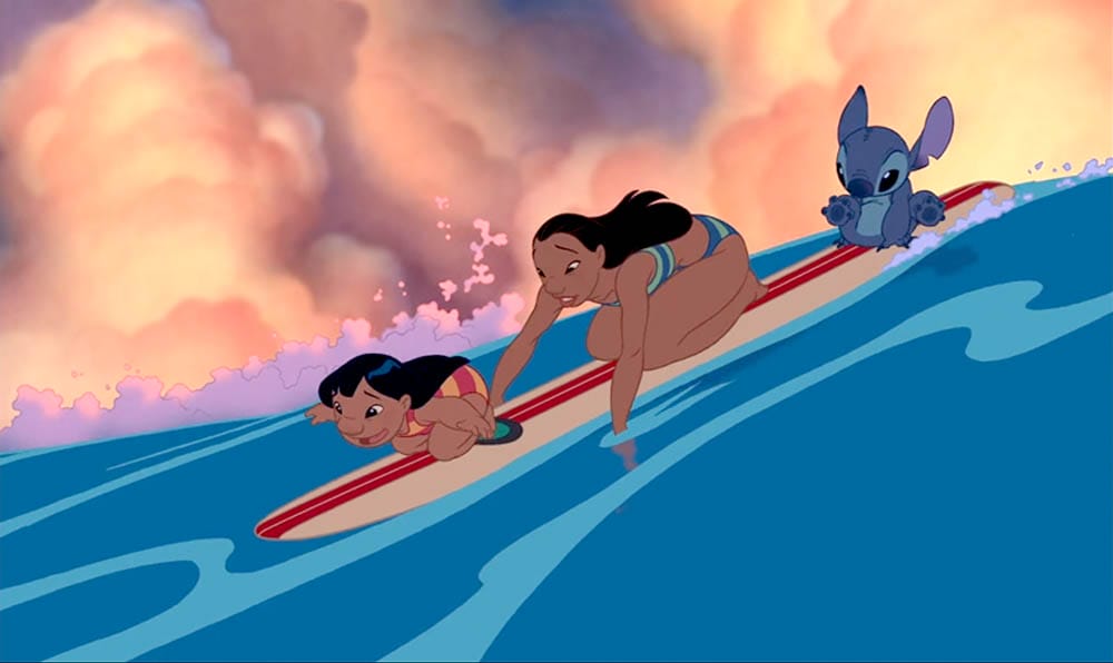 Two girls and a blue alien surf a wave under colorful skies—perfect Stitch wallpaper for free downloads.