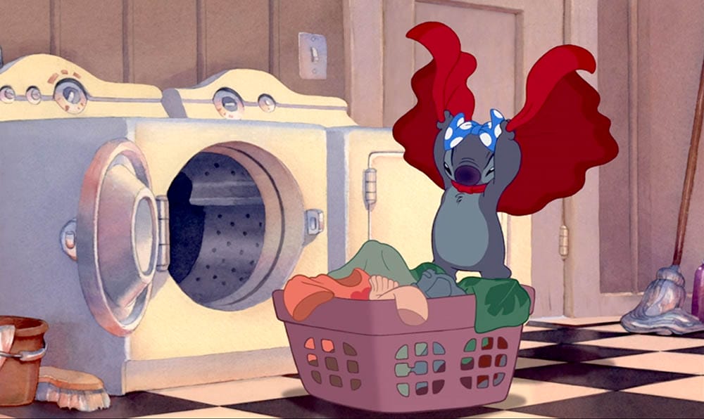 Stitch stands in a laundry basket holding red clothes—perfect Stitch wallpaper for free downloads!