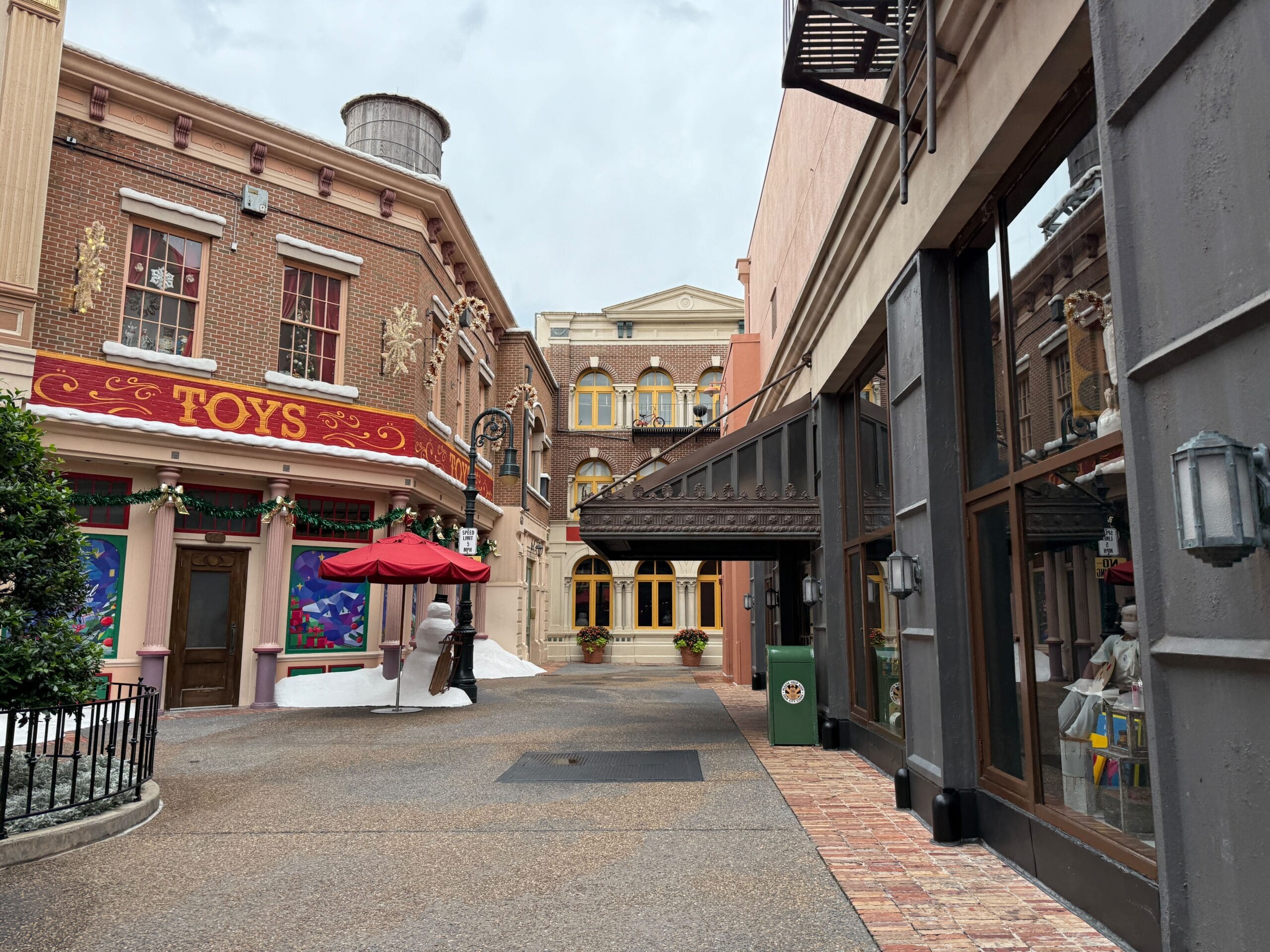 A quaint street with festive decor and old-style brick buildings near the closed Mama Melrose’s Ristorante Italiano.