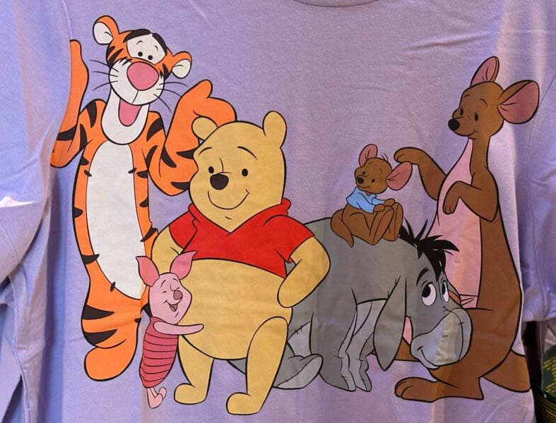 Cartoon image of Disney Characters Tigger, Piglet, Pooh, Eeyore, Kanga, and Roo on a purple shirt.
