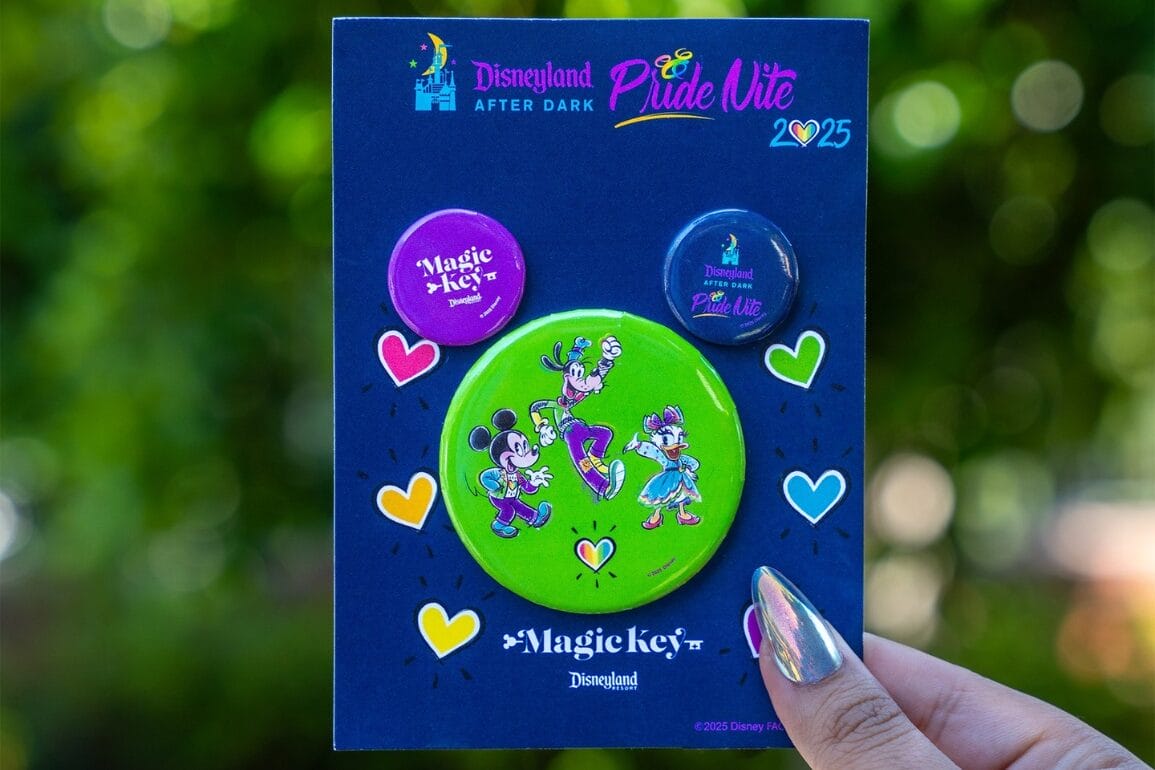A hand holds three colorful Disneyland After Dark: Pride Nite 2025 pins featuring Mickey, Minnie, and friends.