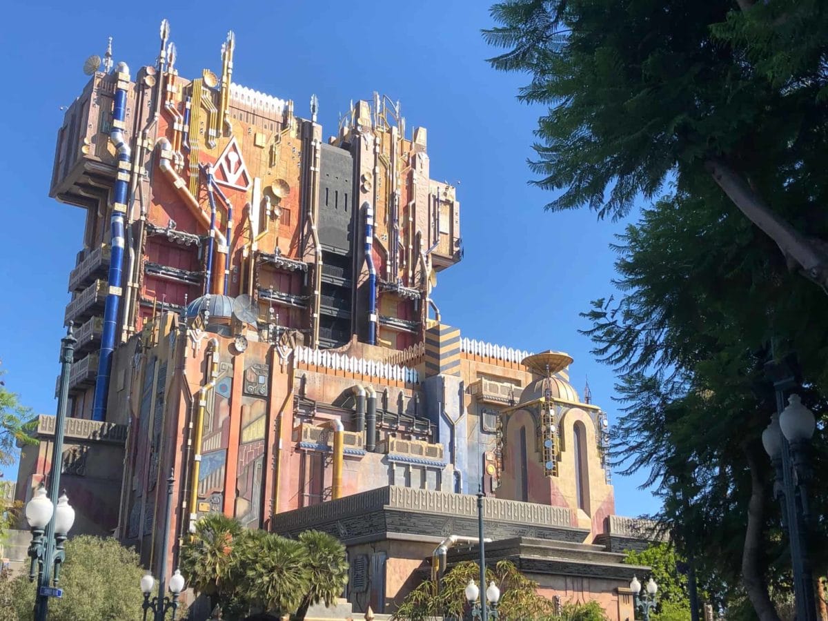 Guardians of the Galaxy Ride building at Disneyland, set against a clear blue sky and trees, plays epic ride songs.