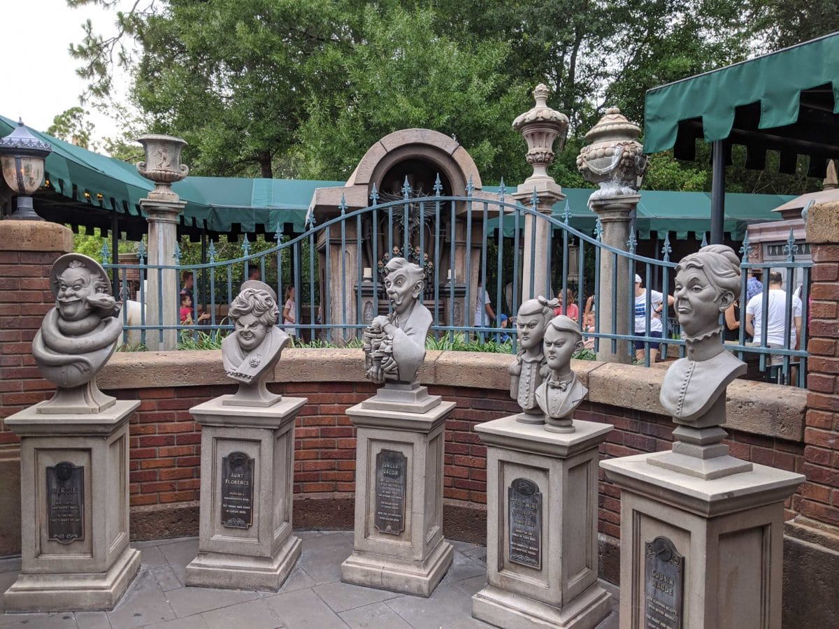 Five whimsical stone busts in the haunted mansion queue at magic kingdom