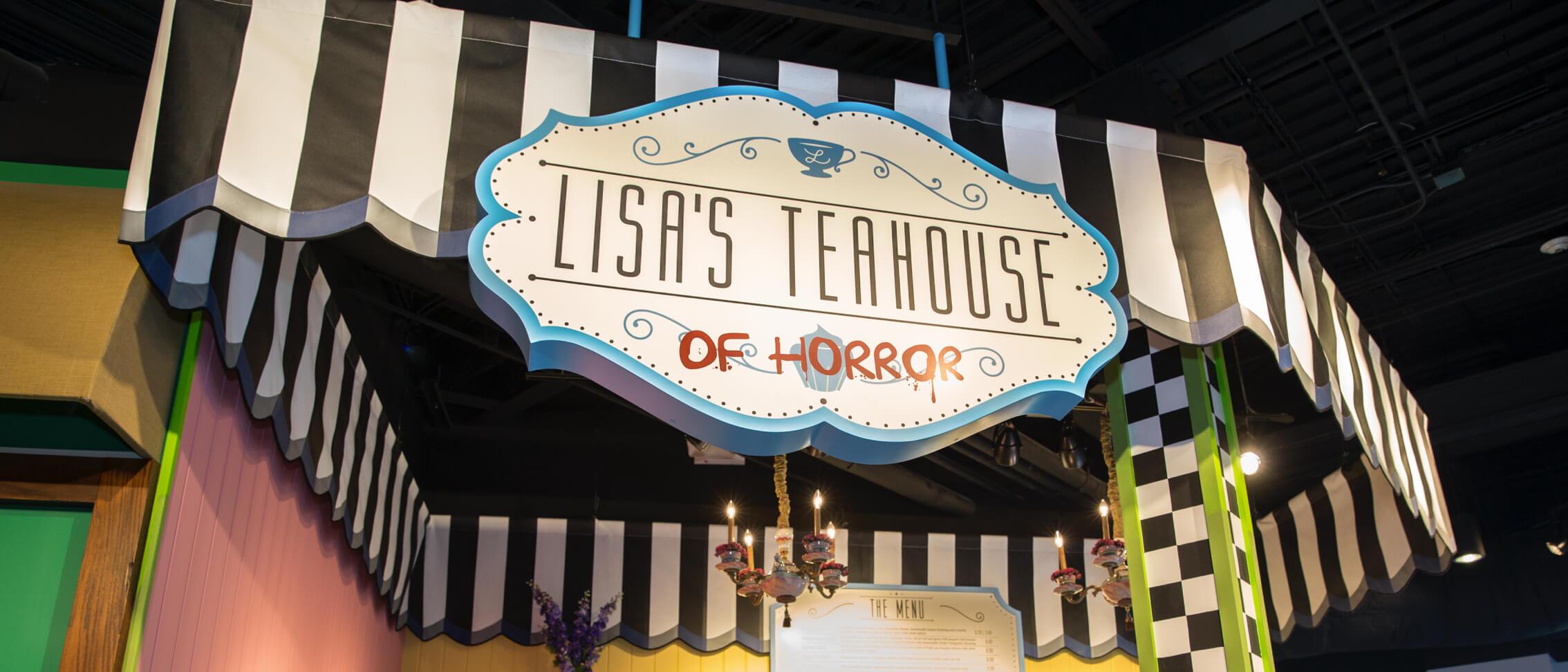 A striped black and white awning with a sign that reads "Lisa's Teahouse of Horror" beside Krusty Burger.
