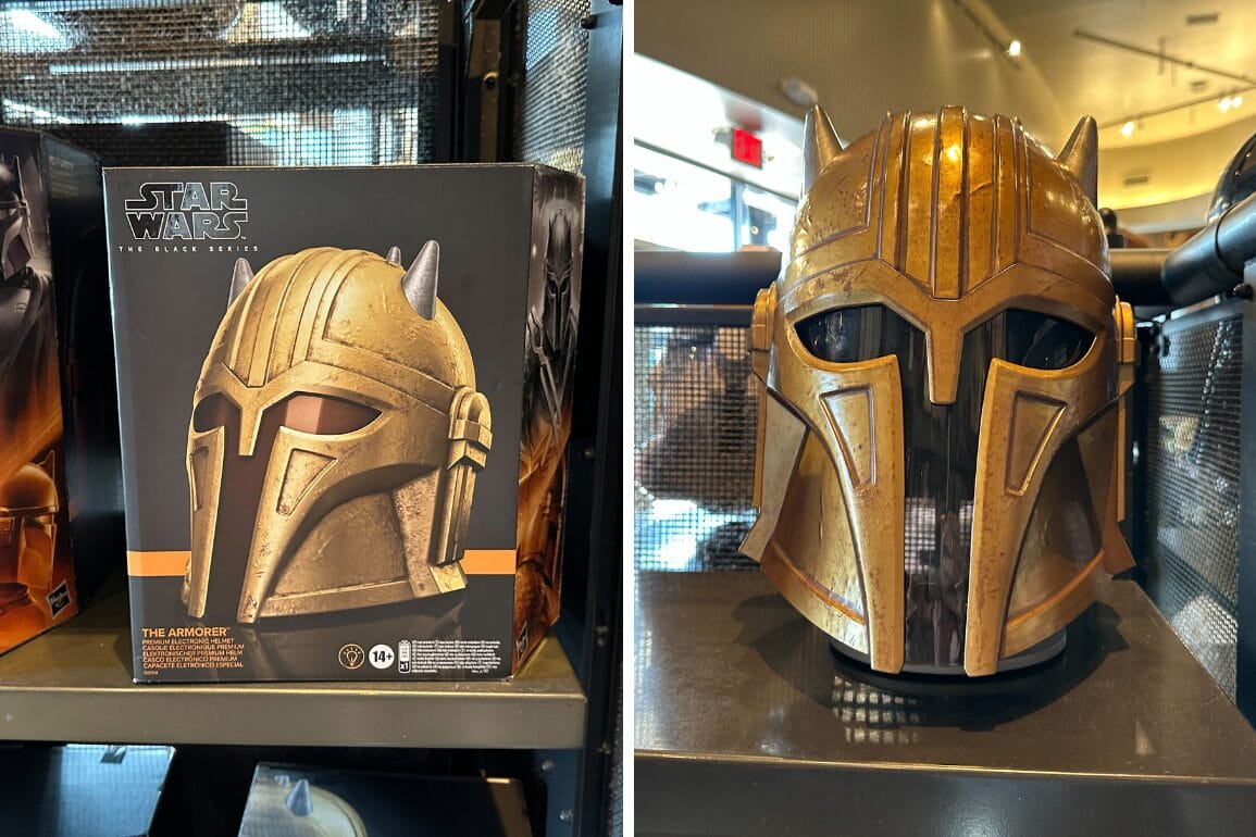 A gold Star Wars The Mandalorian helmet from The Black Series on display next to its box in a store.