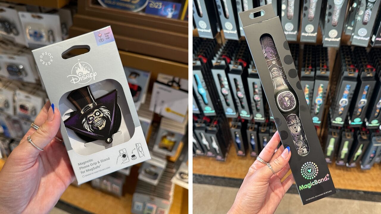 A person holds two Haunted Mansion MagicBand+ in a store, surrounded by other bands and Hatbox Ghost Pop Socket displays.