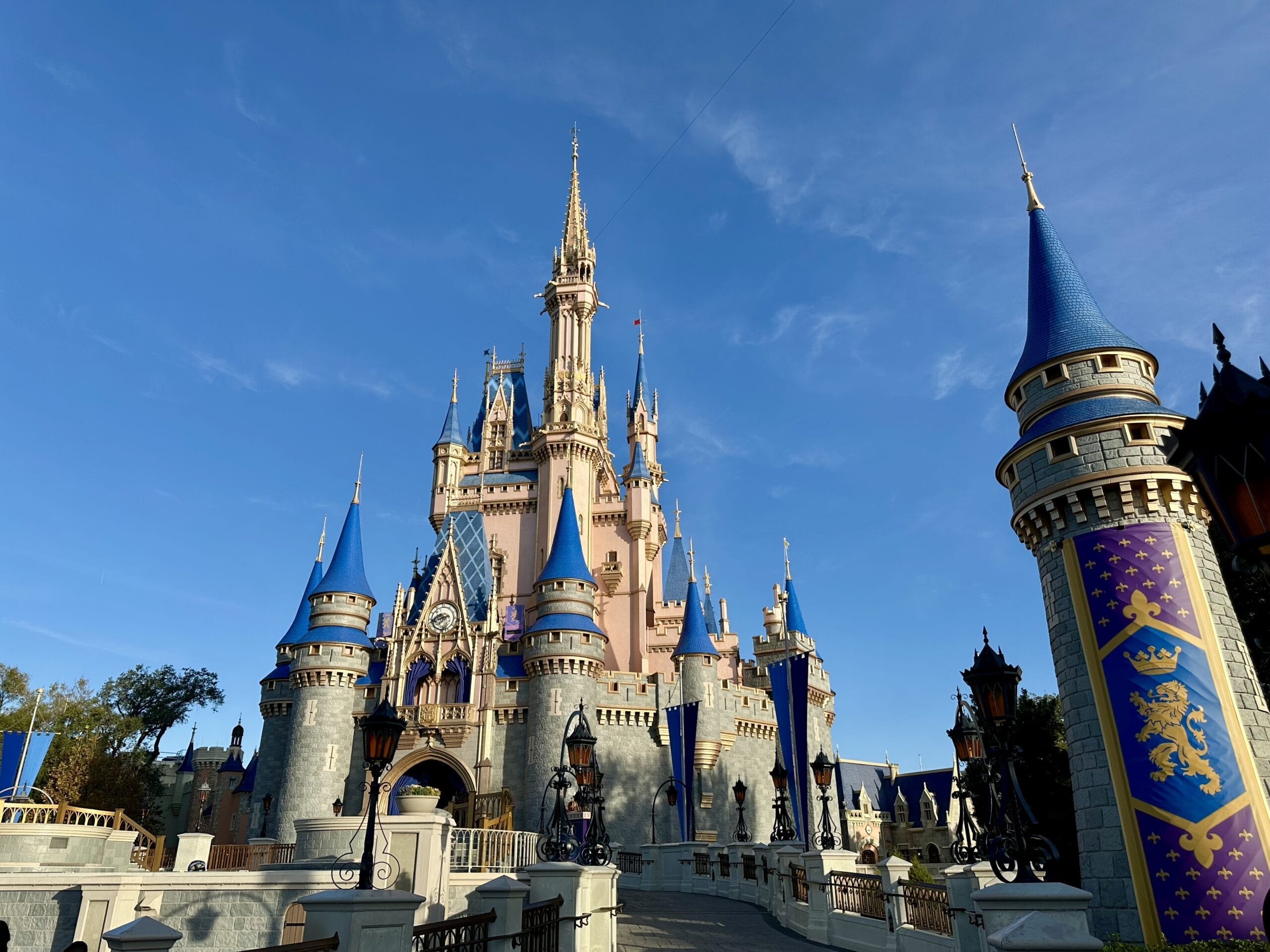Cinderella castle with blue spires and gold accents shines at Disney World Magic Kingdom Annual Pass