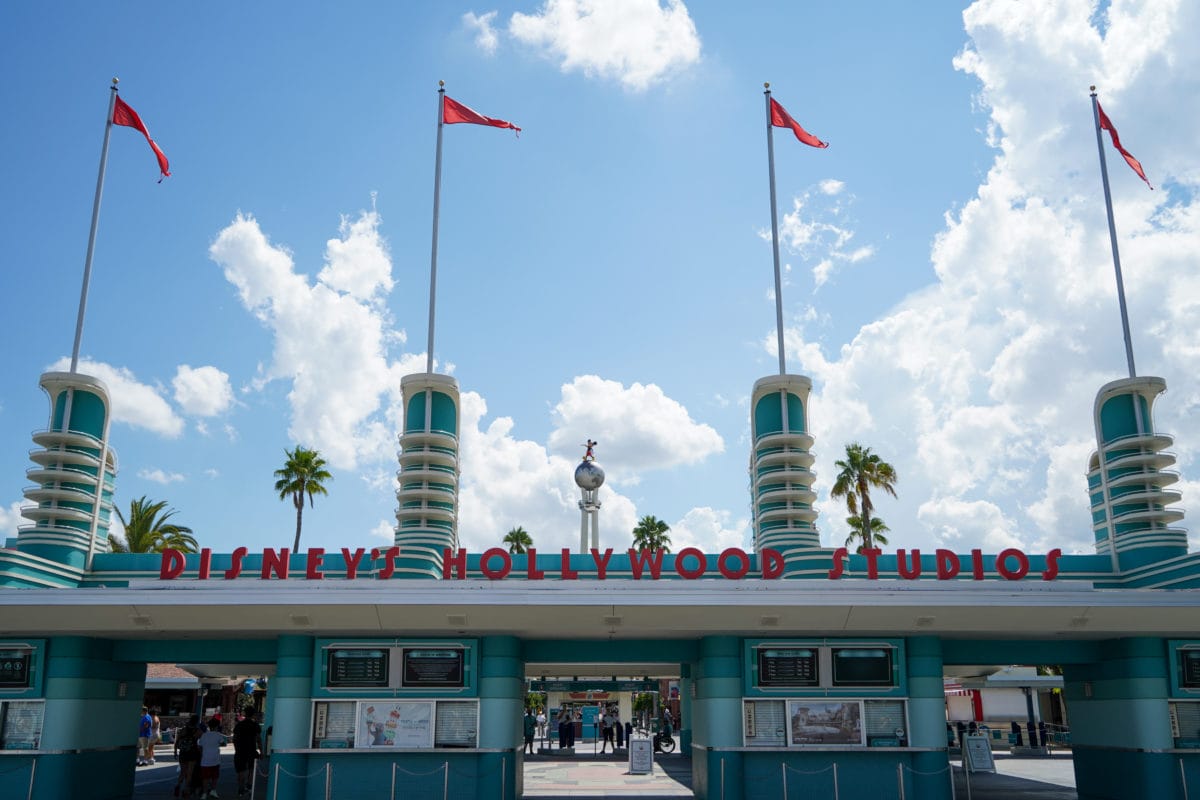 Entrance of Disney’s Hollywood Studios with art deco towers, red flags, and blue sky—perfect for Disney Extended Evening Hours. Entrance of Disney’s Hollywood Studios with art deco towers, red flags, and blue sky—perfect for Disney Extended Evening Hours.