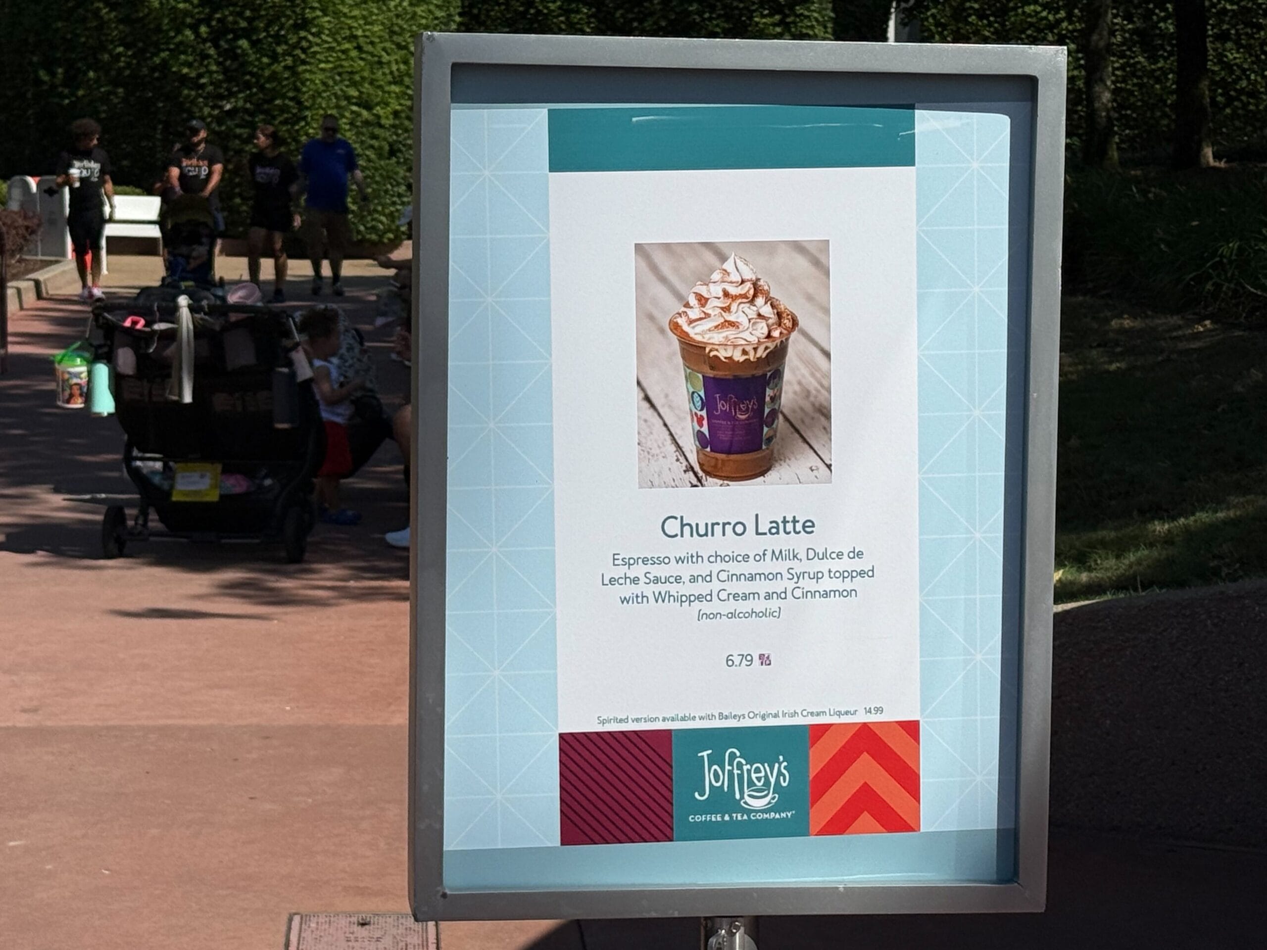 A sign showcases a Food & Wine Churro Latte from Joffrey's Coffee & Tea Company at an outdoor venue.