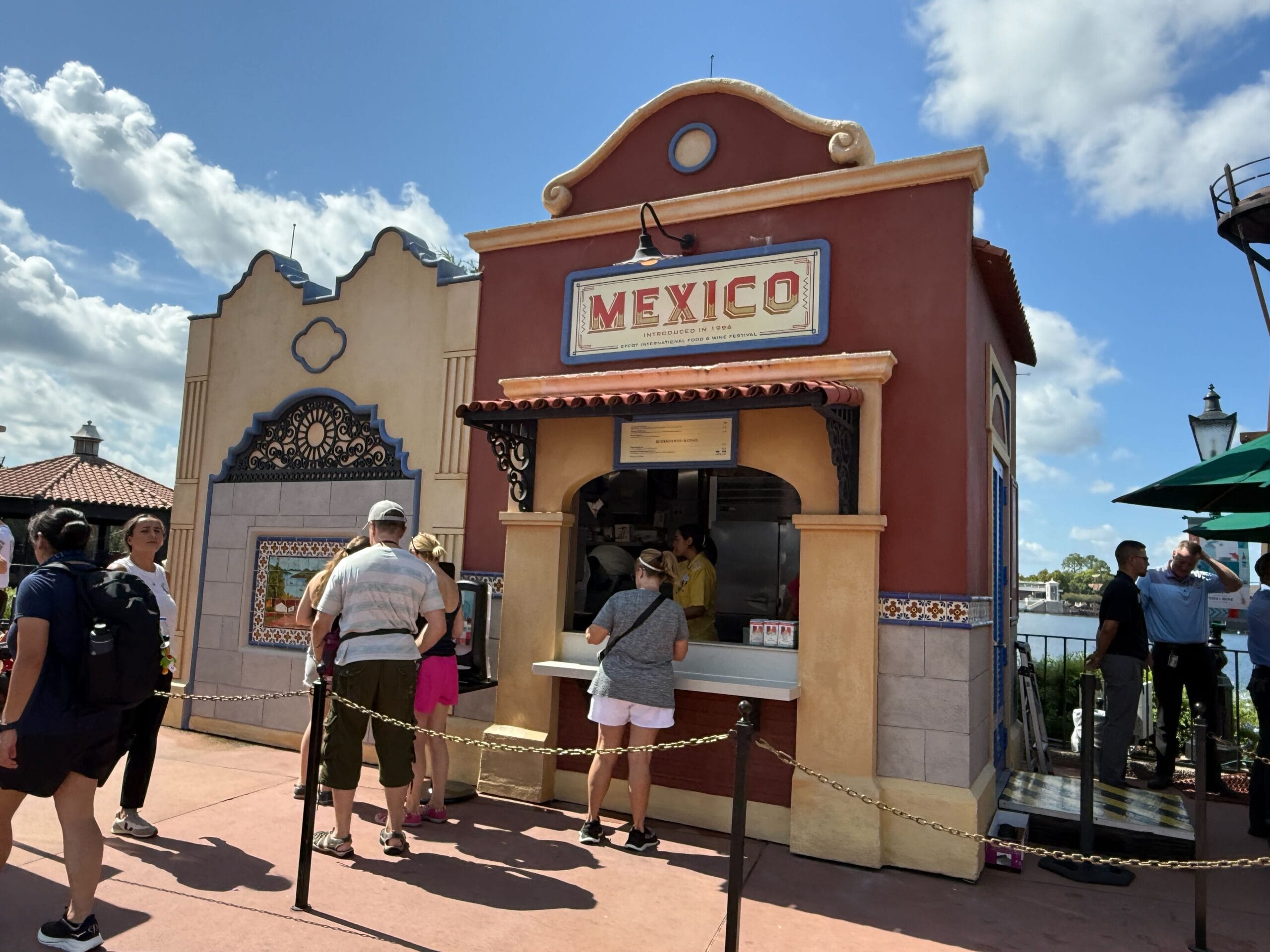 People line up at the "Mexico" stand, eager to try New Food & Wine under a partly cloudy sky.
