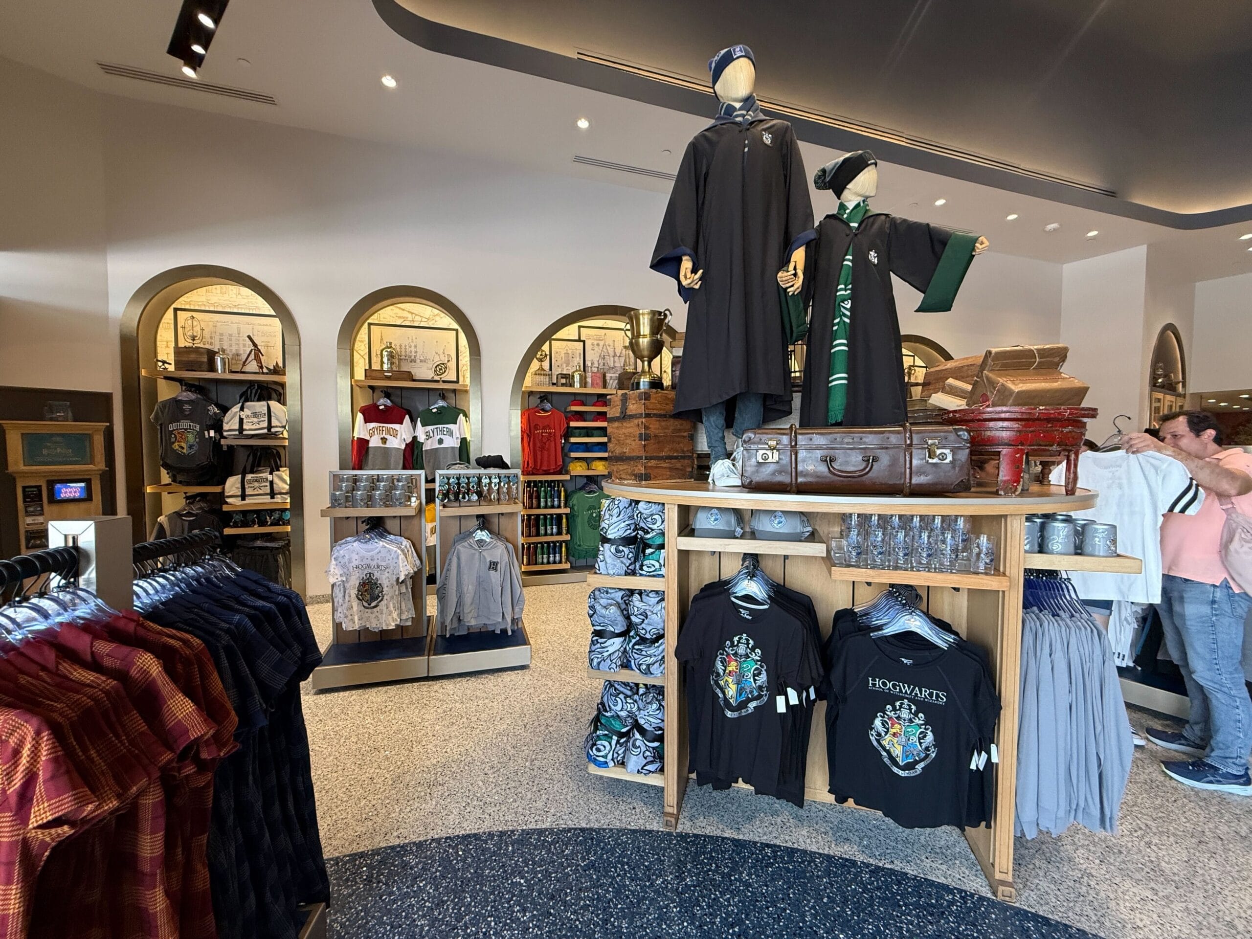 Clothing store with Hogwarts Crest shirts, Harry Potter-themed apparel, and merchandise at Universal Studios Orlando.