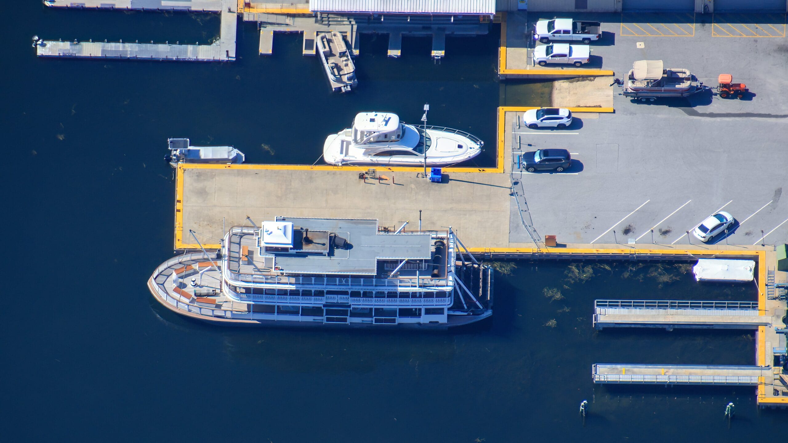 Aerial view of the Liberty Belle Riverboat docked, with parked cars and empty spaces visible below.