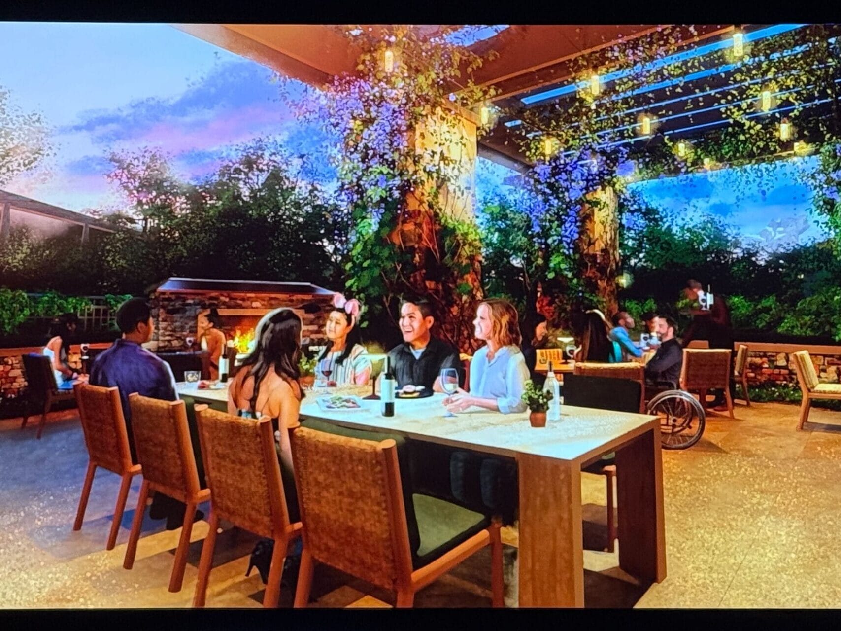 Guests enjoy an evening on a patio with greenery and twinkling lights at Disney's Grand Californian Hotel.