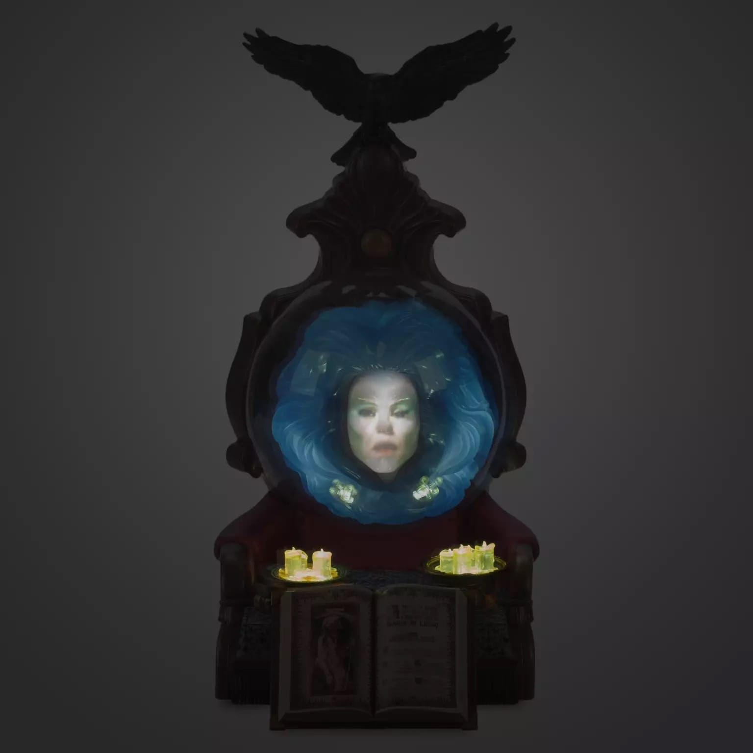 A mystical face appears in a glowing mirror above candles and a spellbook, like a Disney+ fantasy come alive.