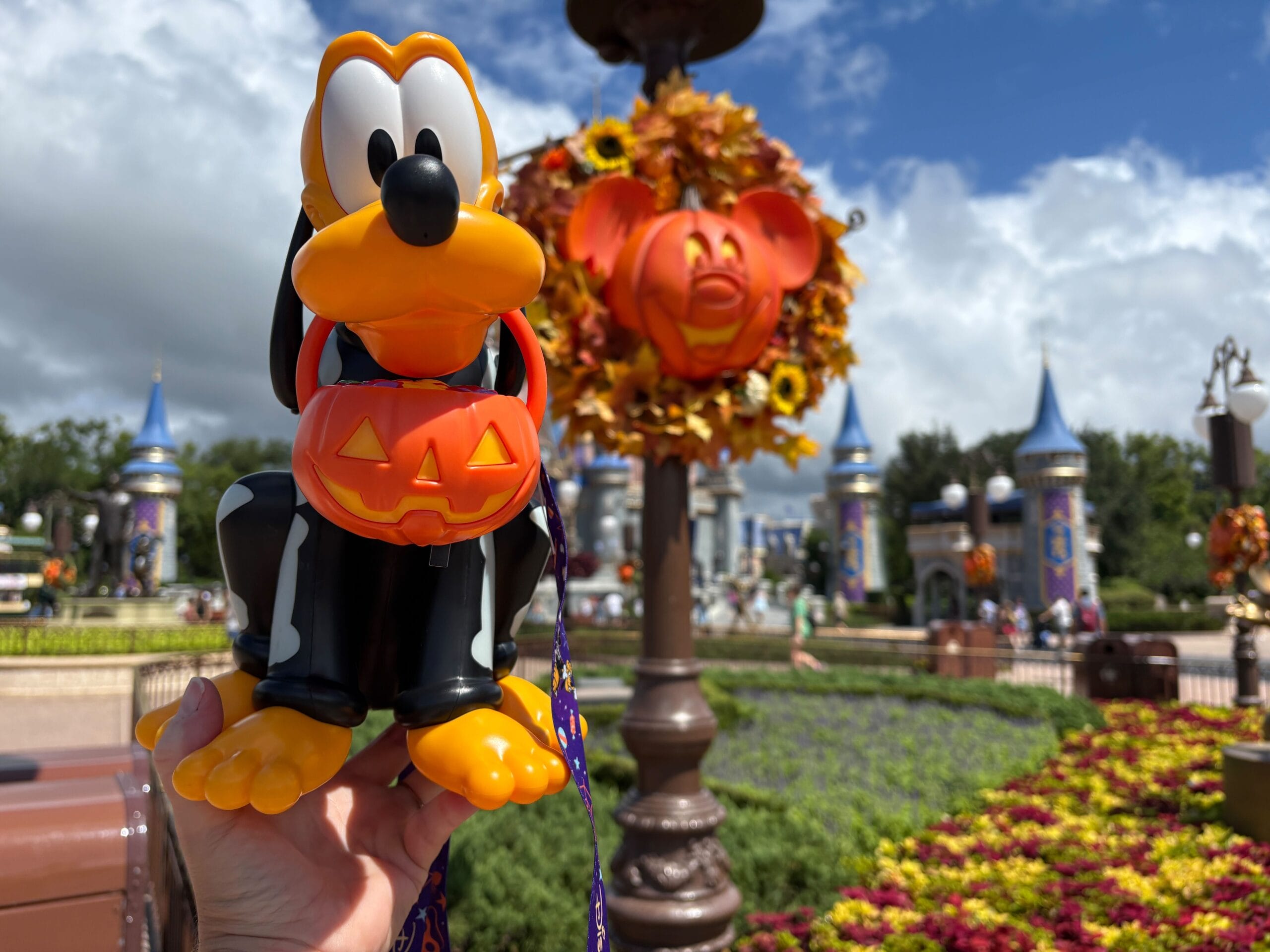 A Pluto Halloween popcorn bucket with festive Mickey pumpkin decor at Disney World, perfect for Halloween 2025.
