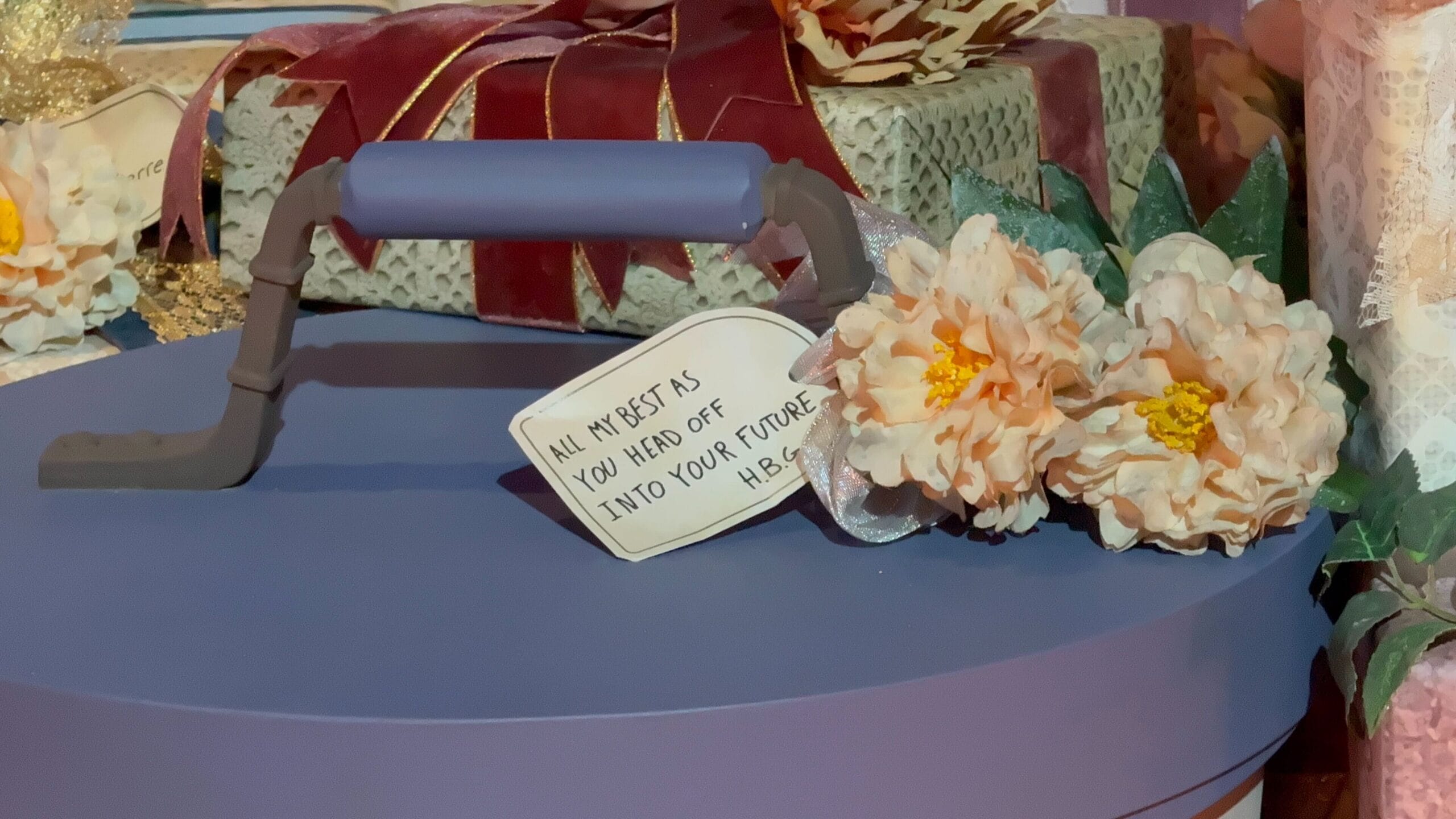 A blue round gift box with flowers and a note, perfect after a day at Disneyland Paris or the Phantom Manor.