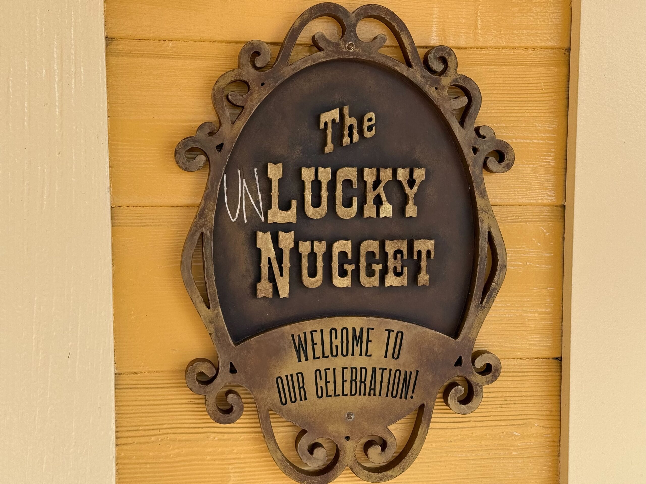 Oval sign reads "The Unlucky Nugget" with text below: "Welcome to our celebration at Disneyland Paris!