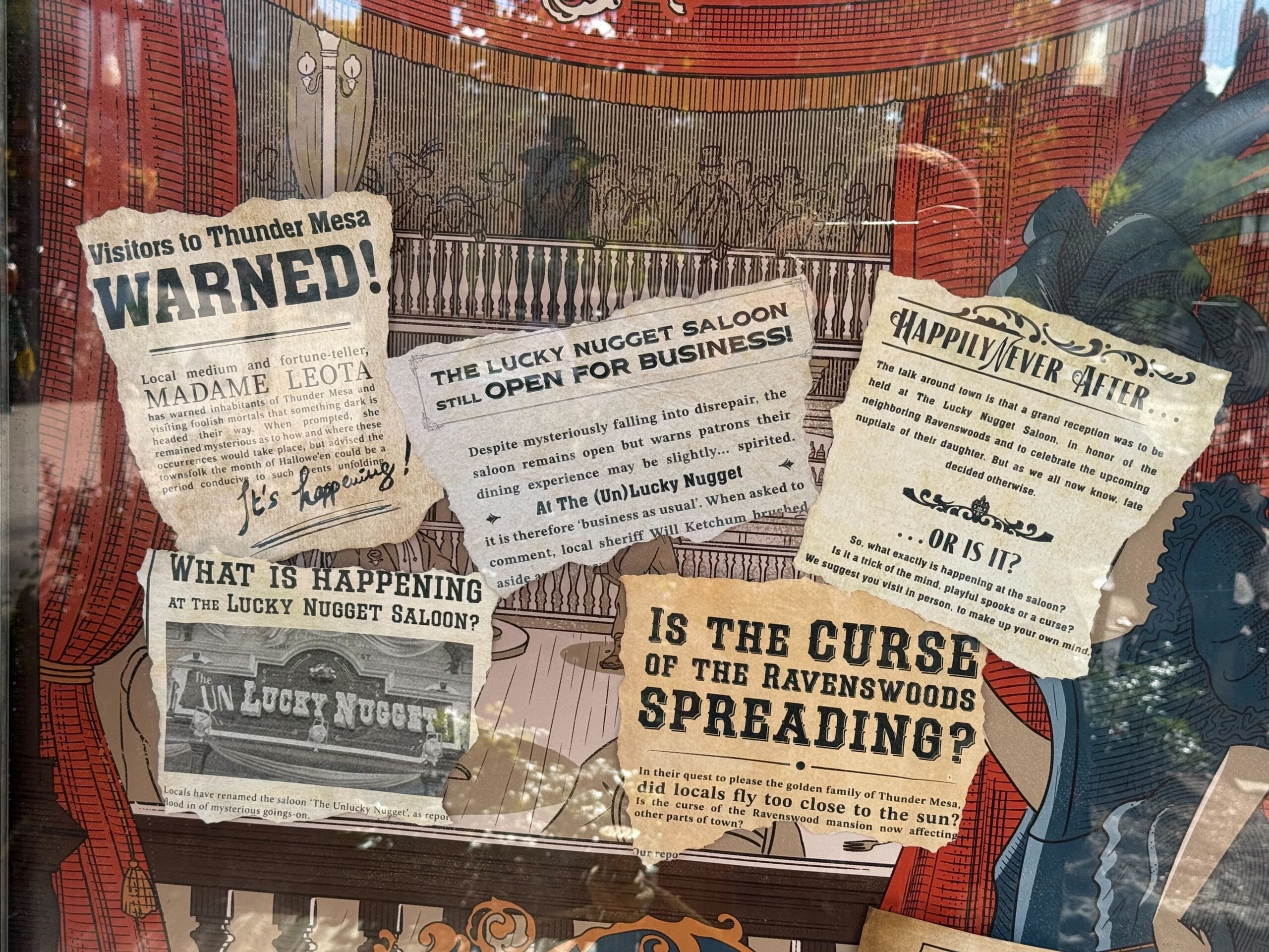 Several vintage-style notices about the Unlucky Nugget Saloon are posted on a glass window at Disneyland Paris.