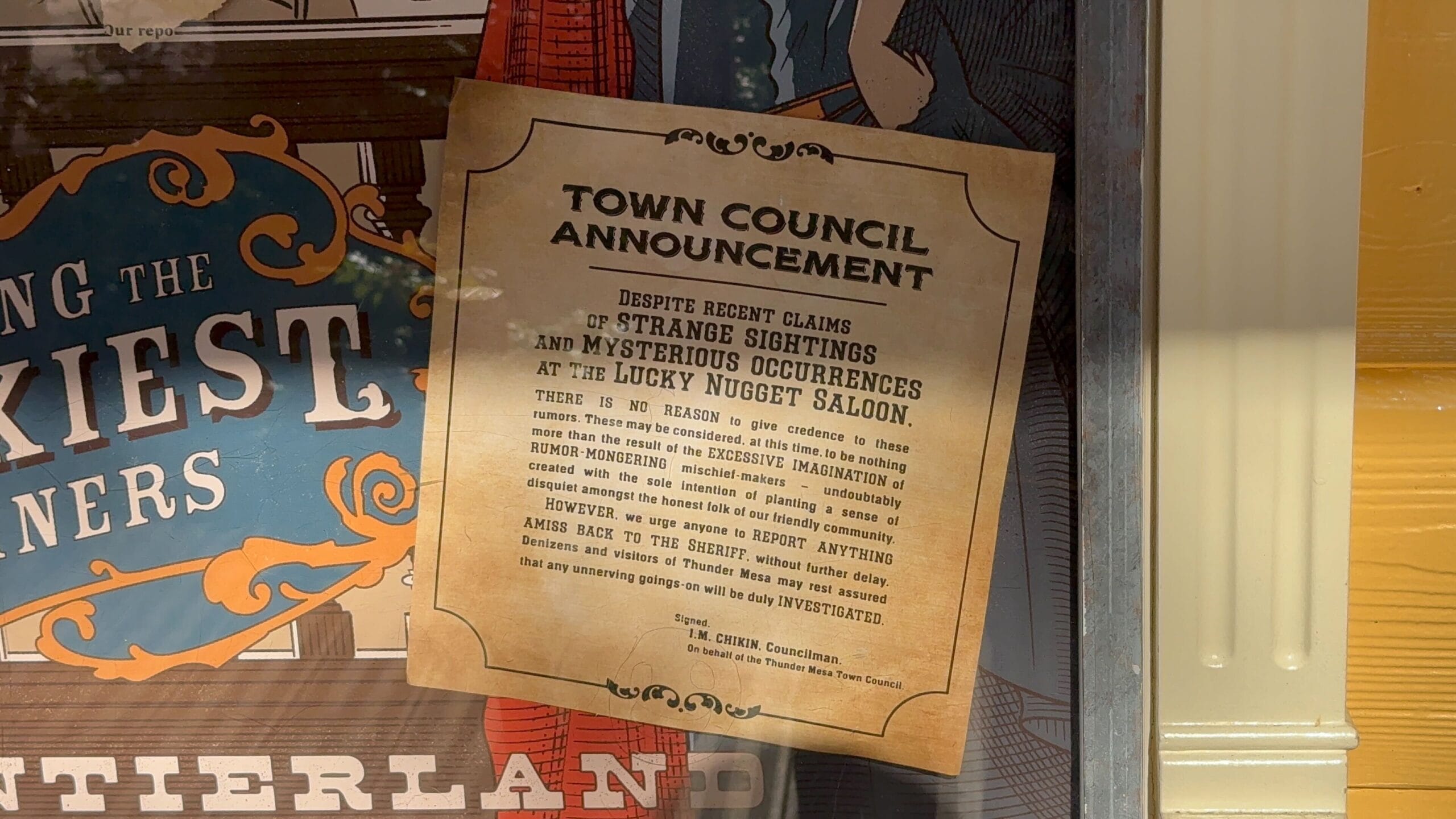 A sepia-toned notice in a window warns of strange sightings at Disneyland Paris's Unlucky Nugget Saloon.