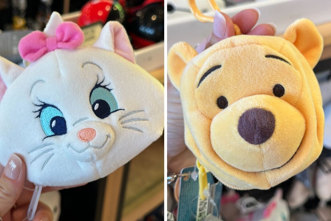 Two plush coin purses shaped like Marie and Pooh are held up for display in a Walt Disney World store.