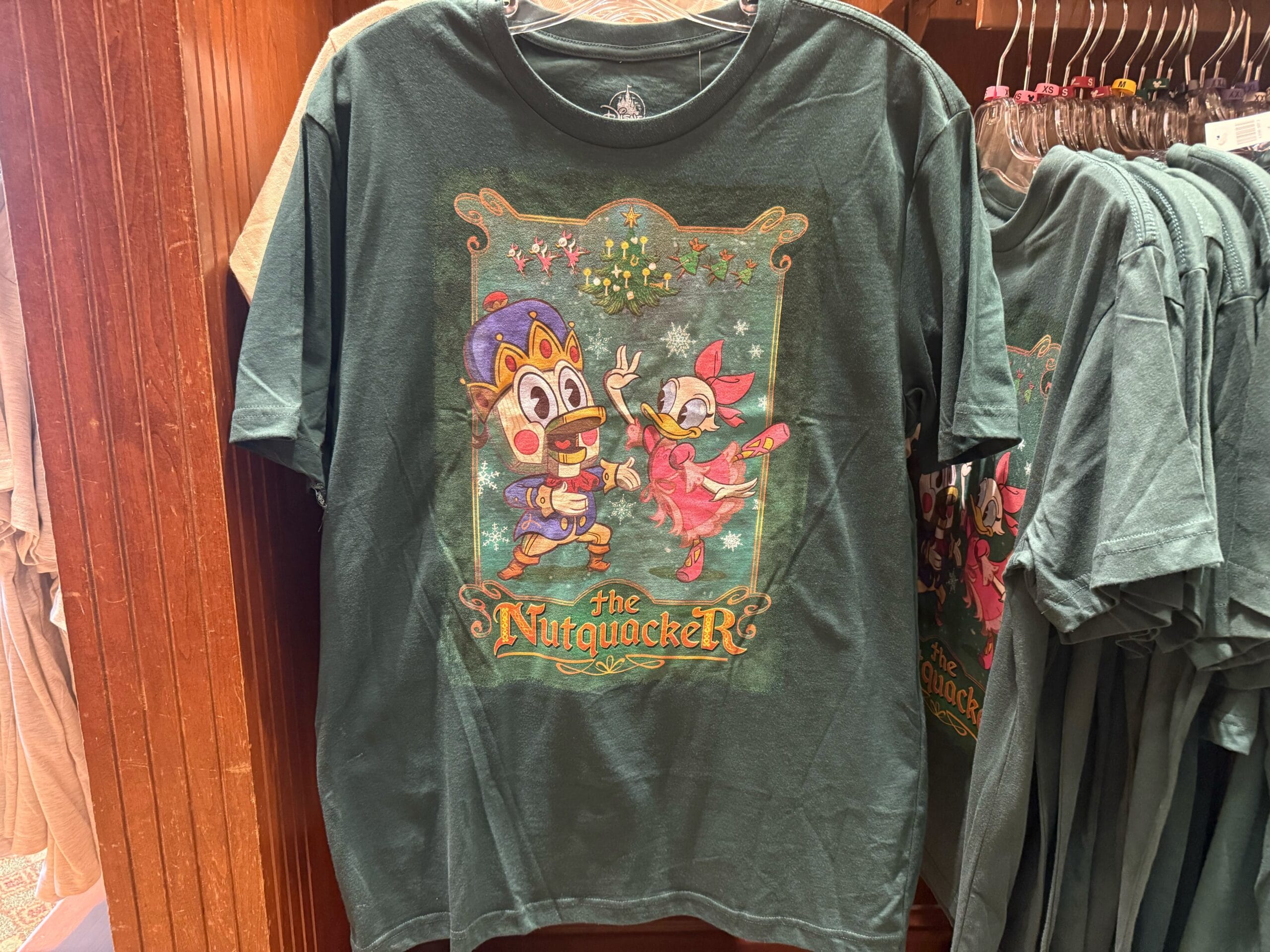 Green tee decorated with animated chipmunks as Nutcracker dancers, inspired by Disneyland holiday shirts—not featuring any castles.