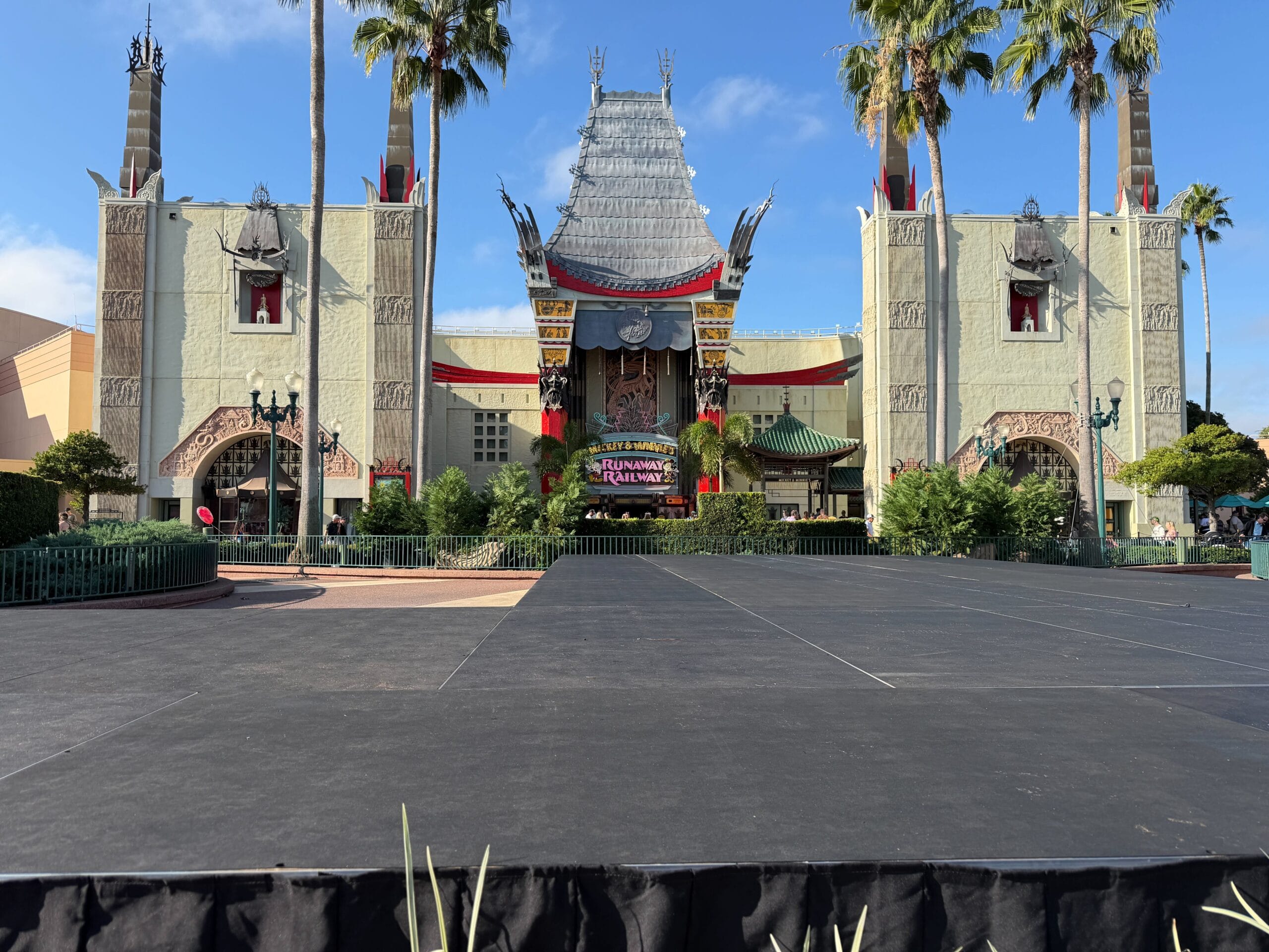 Theater facade at Disney’s Hollywood Studios, resembling the Chinese Theatre, with stage and palm trees.