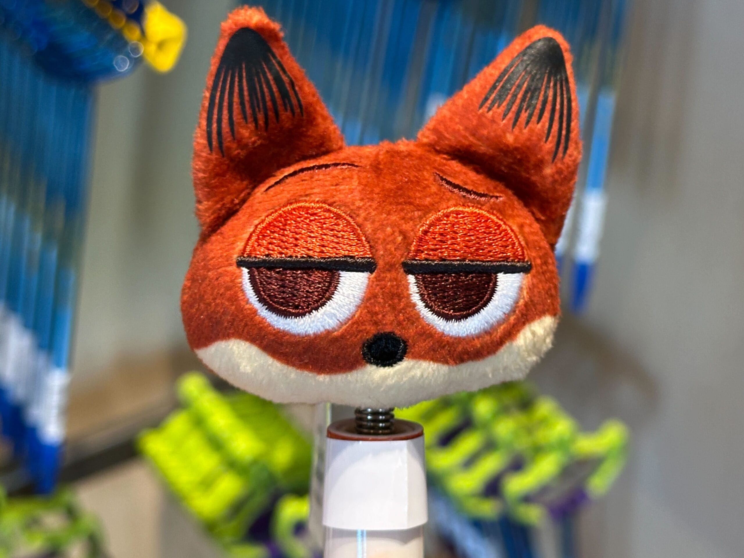 A Zootopia-inspired plush red fox head with droopy eyes and black-tipped ears on display at a Disney park store.