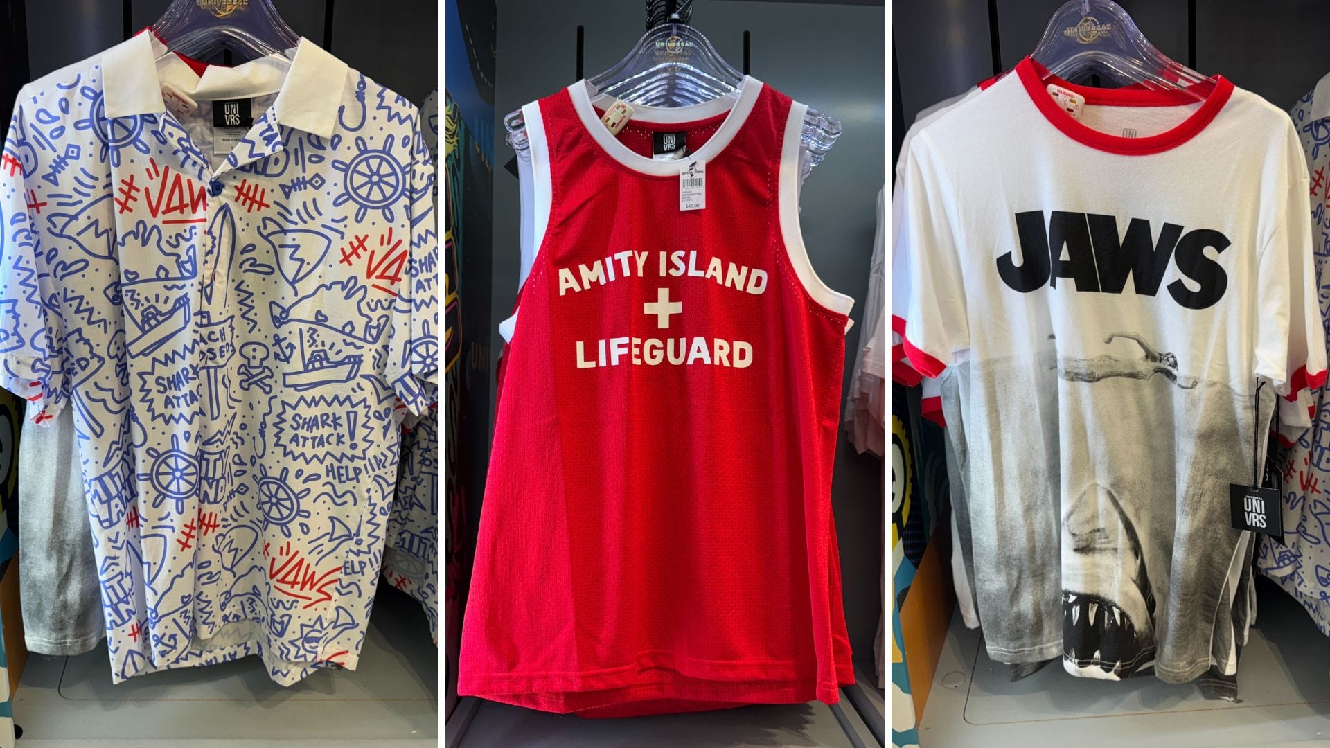 Three shirts: blue-and-white doodle, red "Lifeguard Jersey," and white "JAWS" shark—Universal, not Disney castle themed.